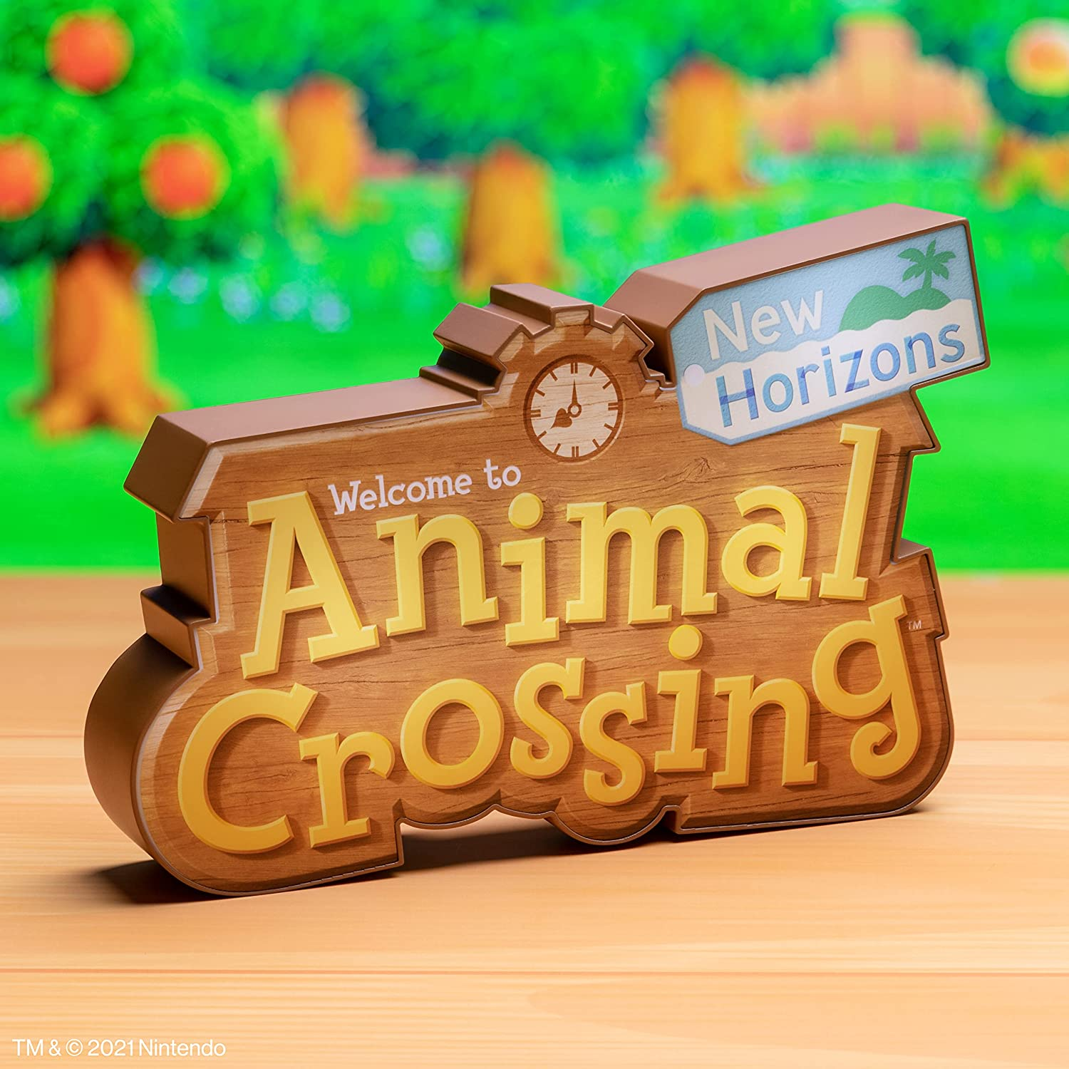 Cartello in legno con 'Benvenuti ad Animal Crossing: New Horizons' su un tavolo.