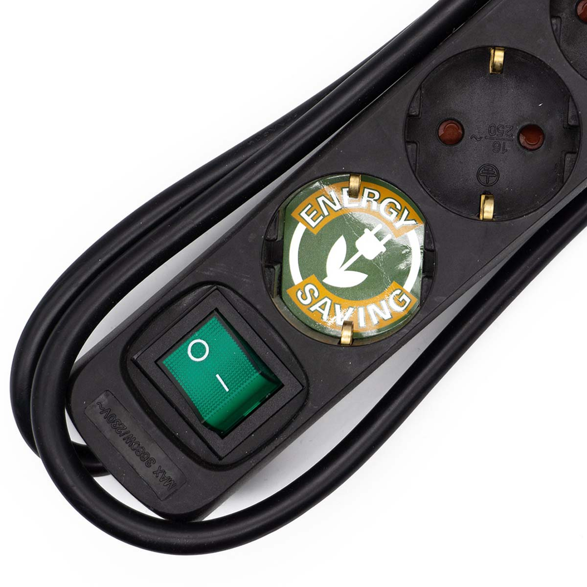 Nahaufnahme einer schwarzen Steckdosenleiste mit grünem Einschaltknopf und Energiesparlogo.