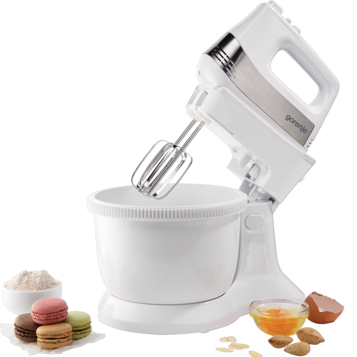 Weißer Küchenmixer mit Aufsätzen, Schüssel und Zutaten wie Mehl, Ei und Makronen.