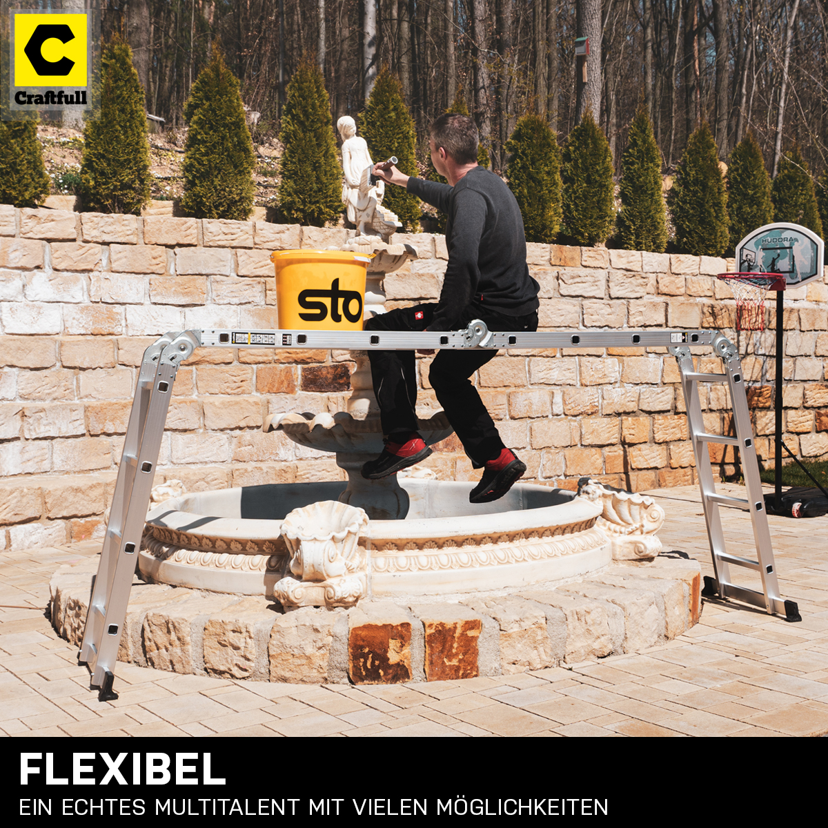 Mann malt eine Statue von einer Leiter aus. Gelber Eimer. Text: FLEXIBEL, EIN ECHTES MULTITALENT MIT VIELEN MÖGLICHKEITEN.