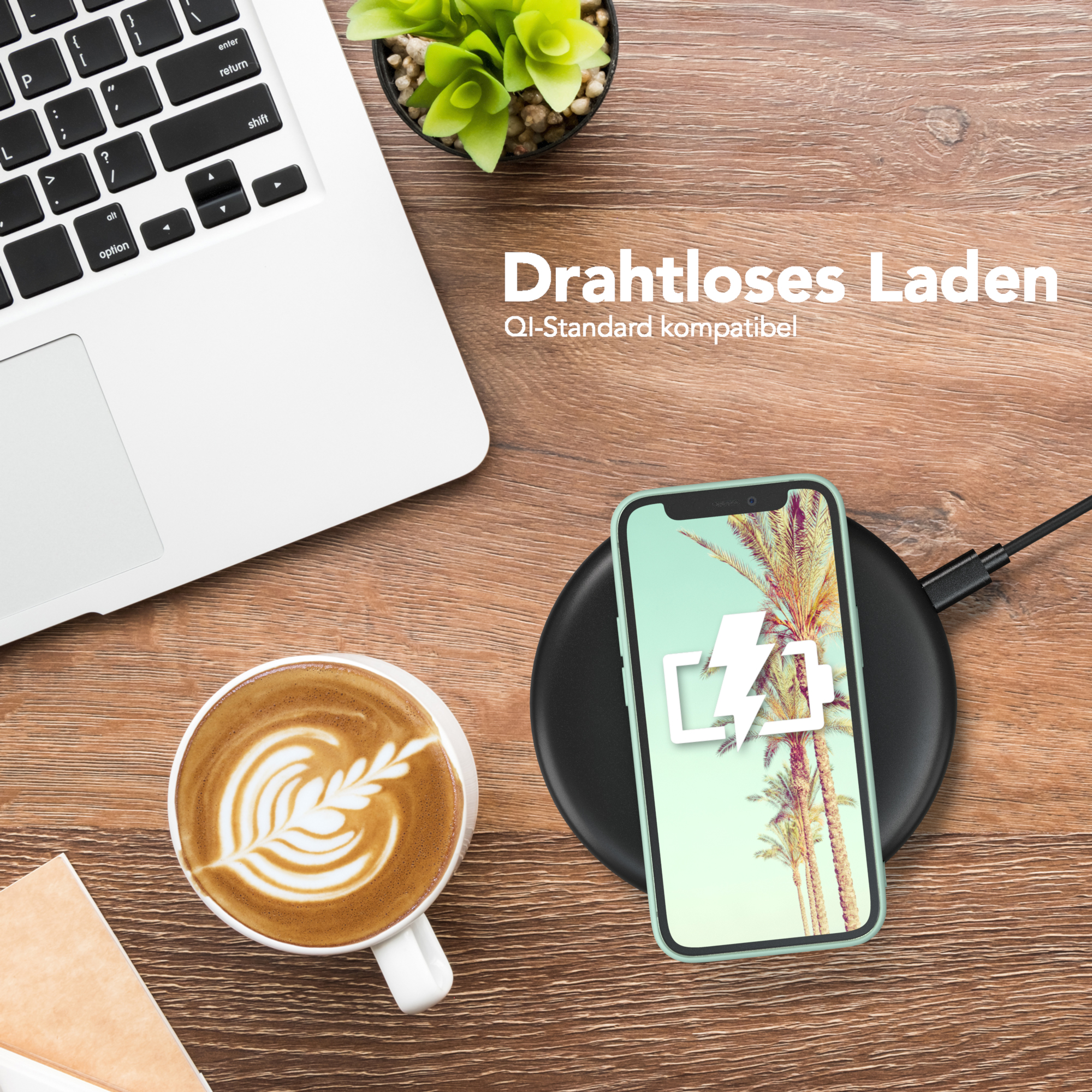 Ein Telefon auf einem kabellosen Ladegerät, Laptop und Kaffeetasse daneben.