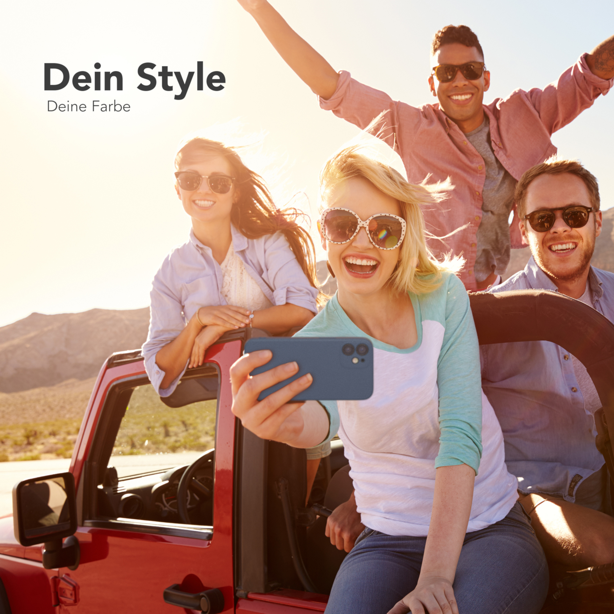 Gruppe von vier Personen in einem roten Auto, die ein Selfie machen. Die Szene ist sonnig und draußen.