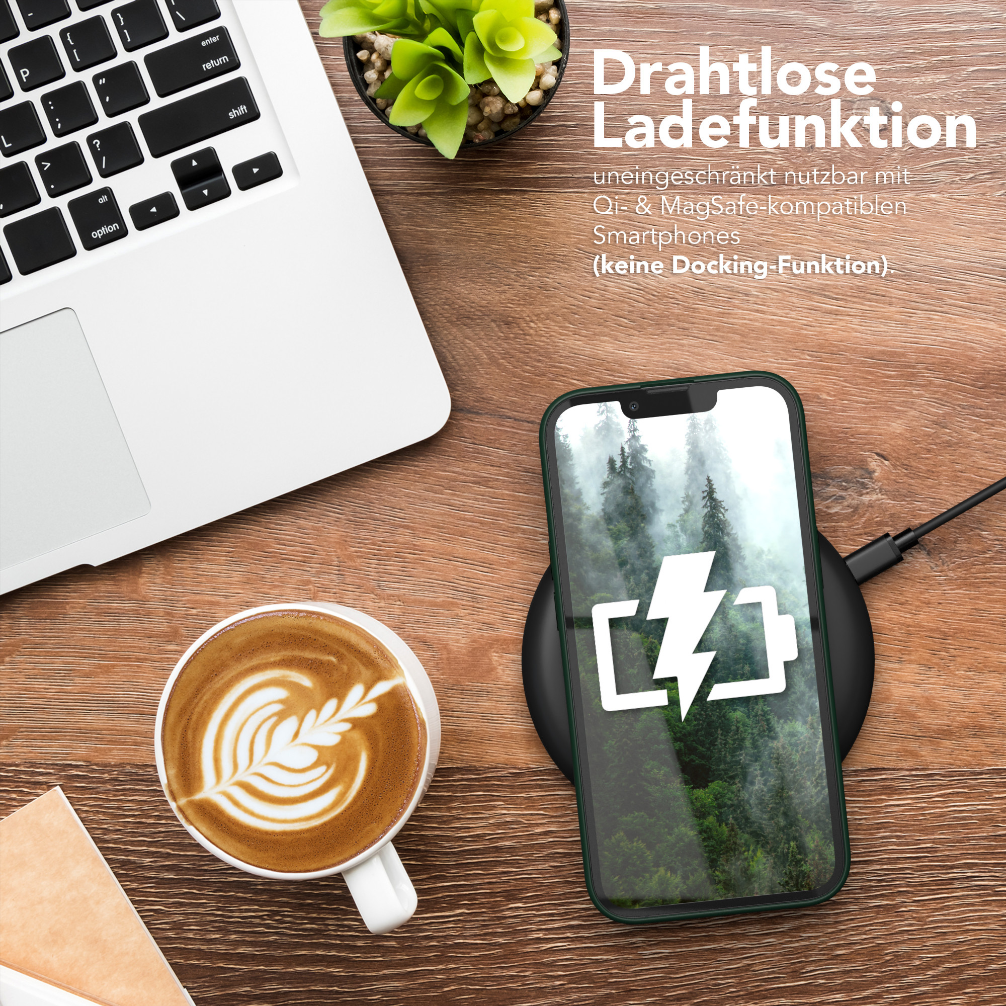 Ein Laptop, eine Kaffeetasse und ein Telefon, das auf einem kabellosen Ladegerät geladen wird. Eine Pflanze im Hintergrund.