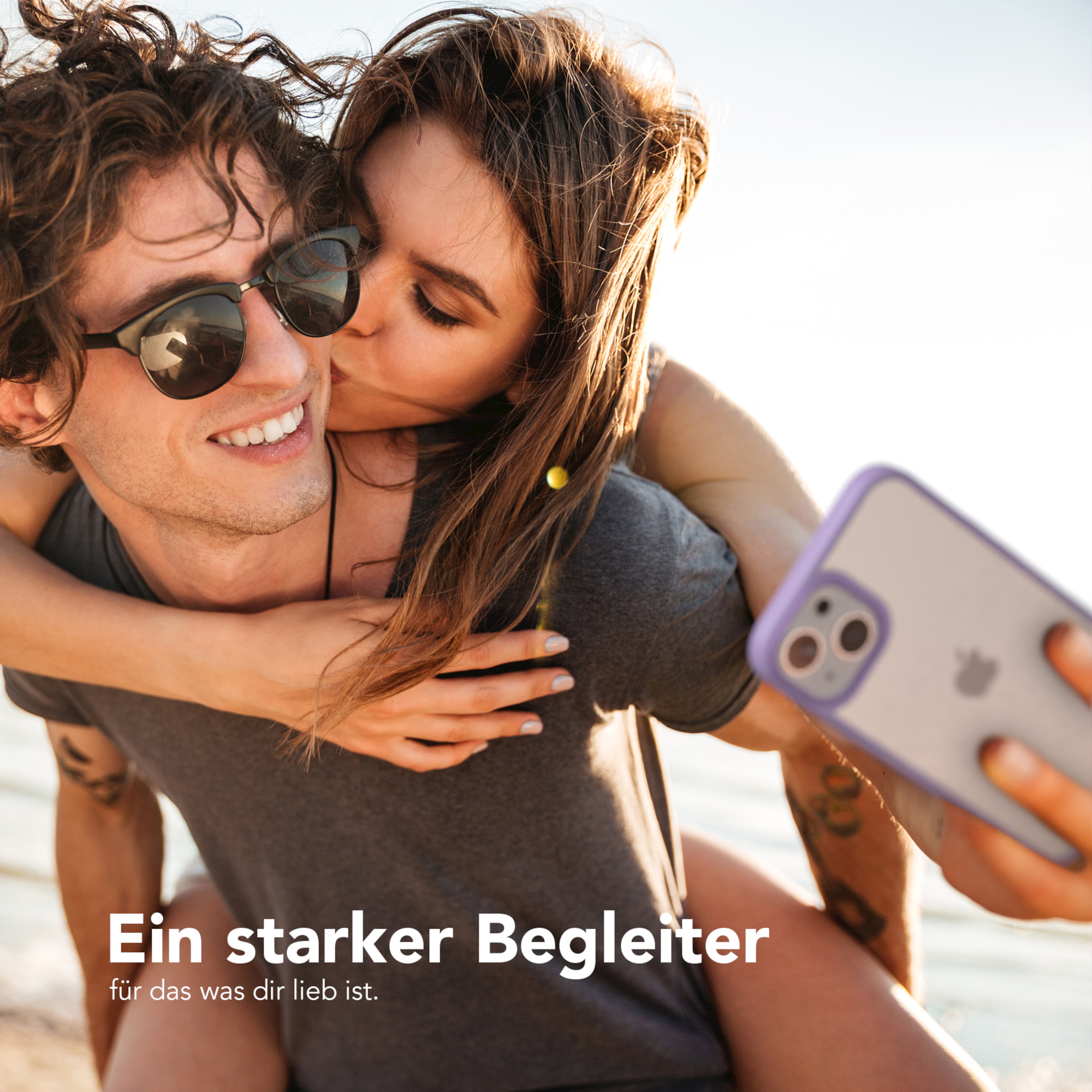 Ein Paar macht ein Selfie, die Frau küsst den Mann, mit einer Handyhülle mit durchsichtigem Rücken.
