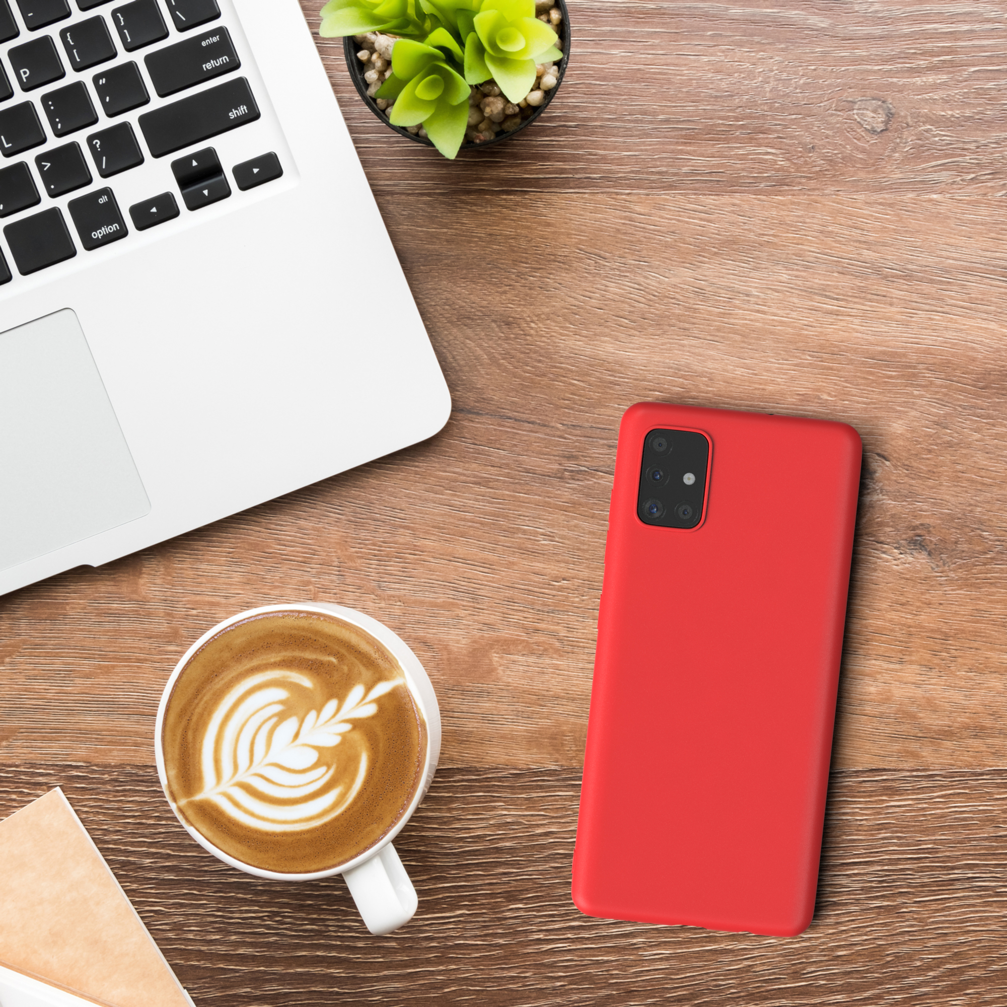 Laptop, Kaffee, Telefon und Handyhülle auf einem Holztisch.