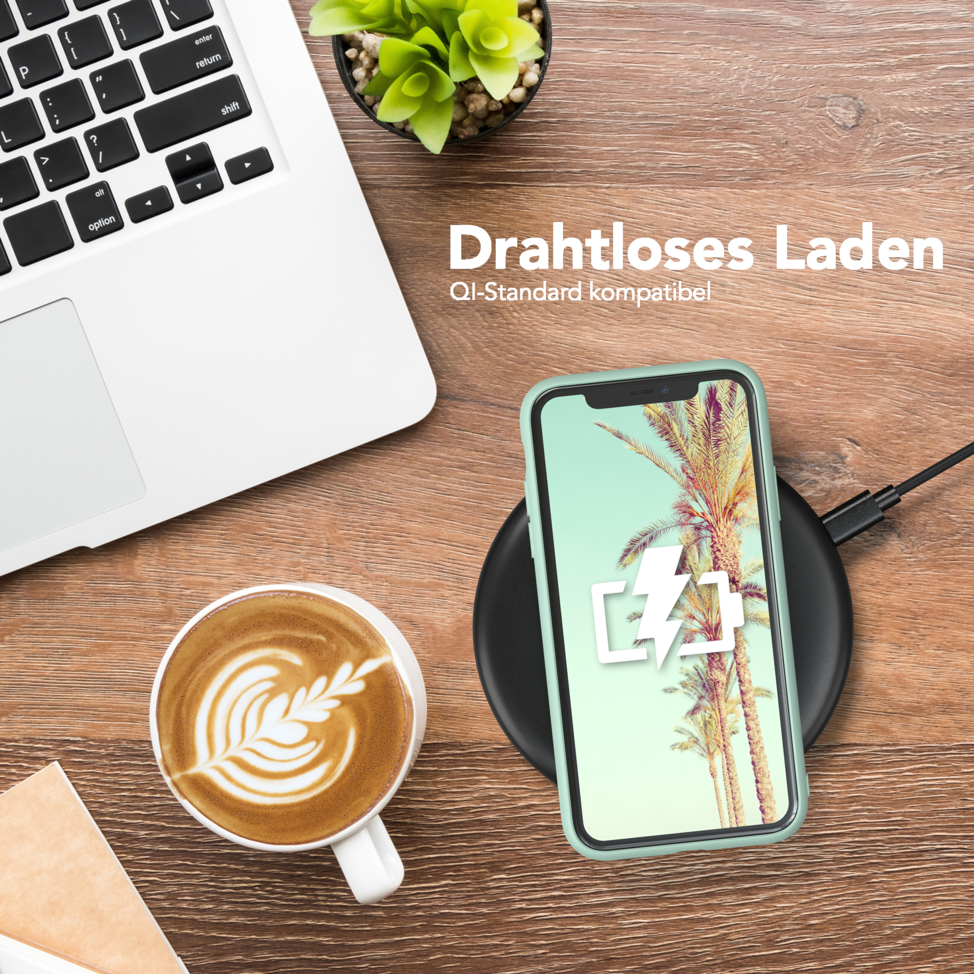 Laptop, Kaffee mit Latte Art, Telefon auf kabellosem Ladegerät. Palmenbild auf dem Telefonbildschirm.