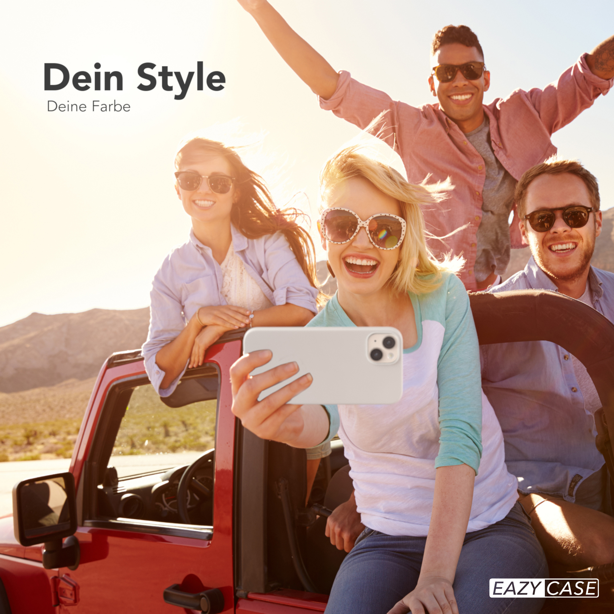 Vier Personen in einem roten Jeep machen ein Selfie. Sie alle lächeln und die Sonne scheint.