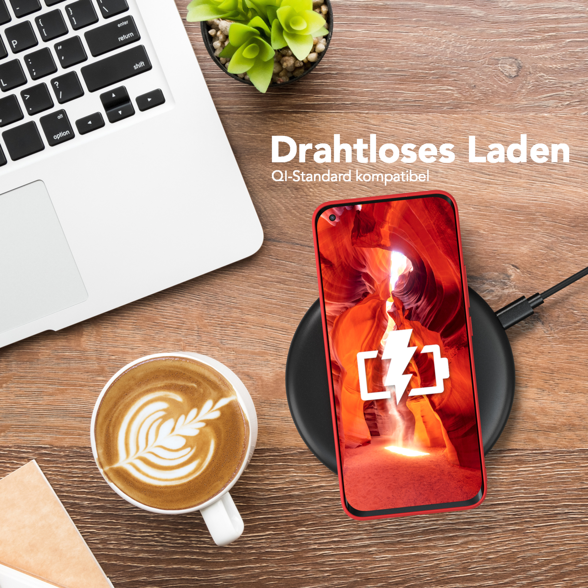 Telefon auf kabellosem Ladegerät, neben Kaffee und Laptop, auf einem Holztisch.