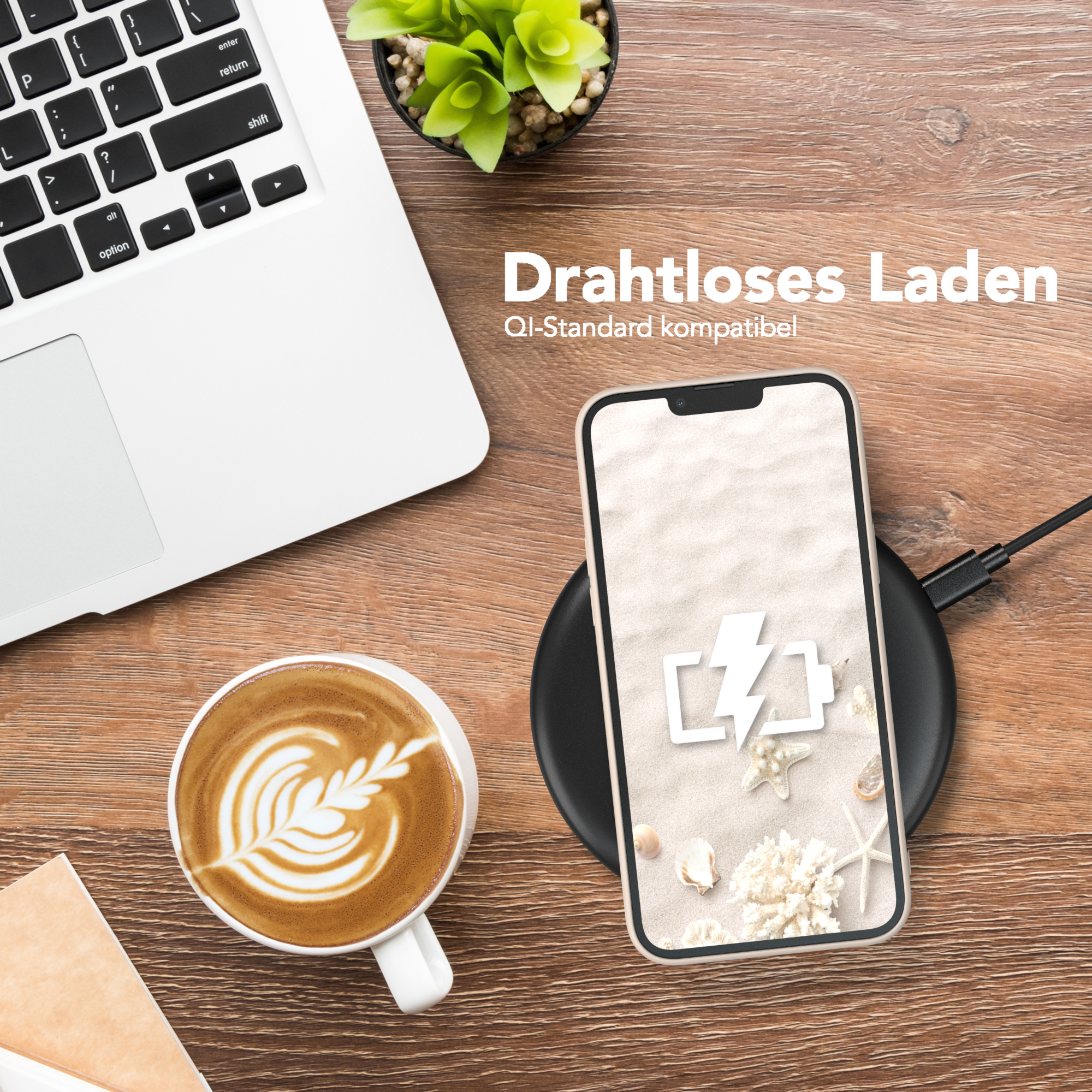 Telefon auf kabellosem Ladegerät, neben einem Laptop und einer Tasse Kaffee mit Latte Art.