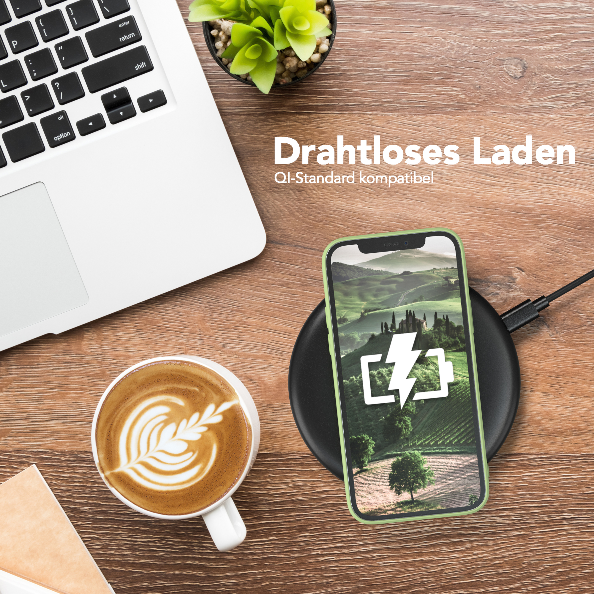 Telefon auf kabellosem Ladegerät, neben Laptop und Kaffee. Telefon zeigt Landschaft.