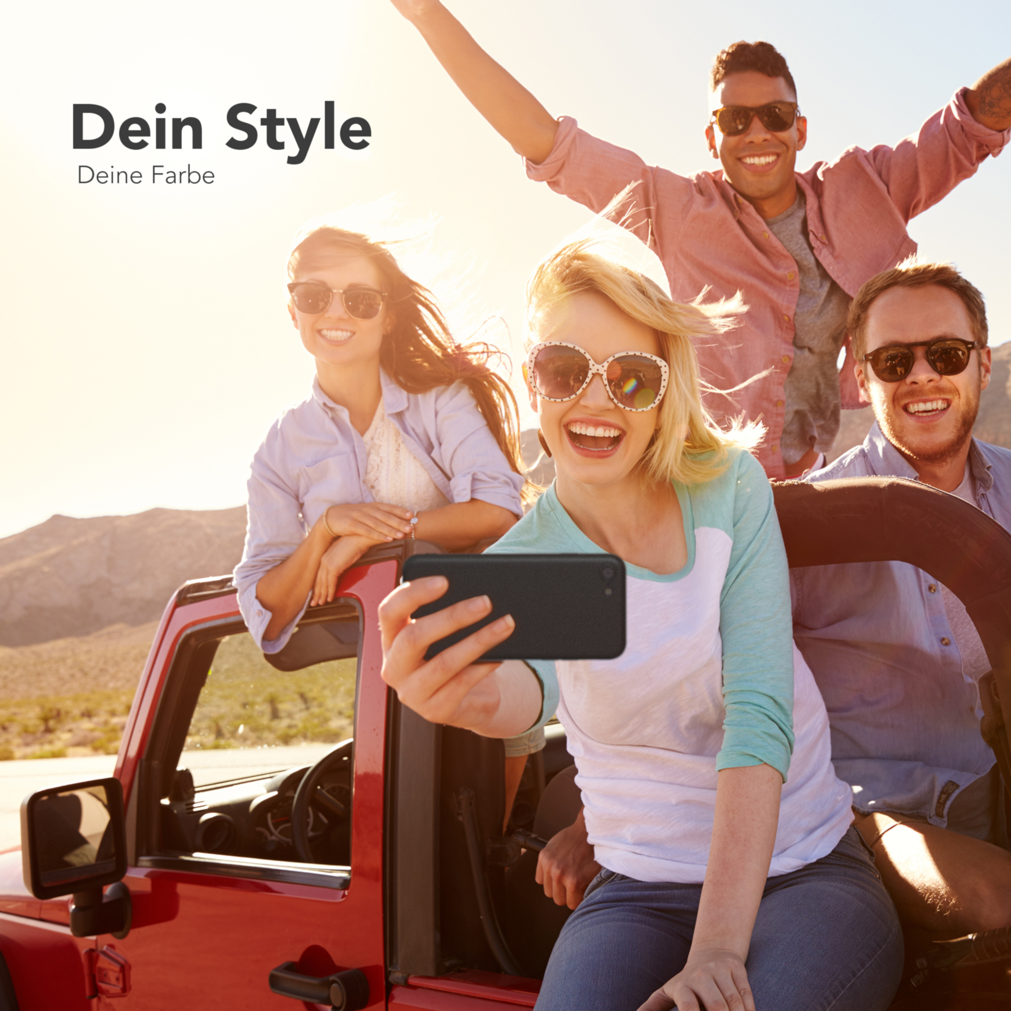 Gruppe von Leuten in einem roten Jeep, einer macht ein Selfie mit einer schwarzen Handyhülle.
