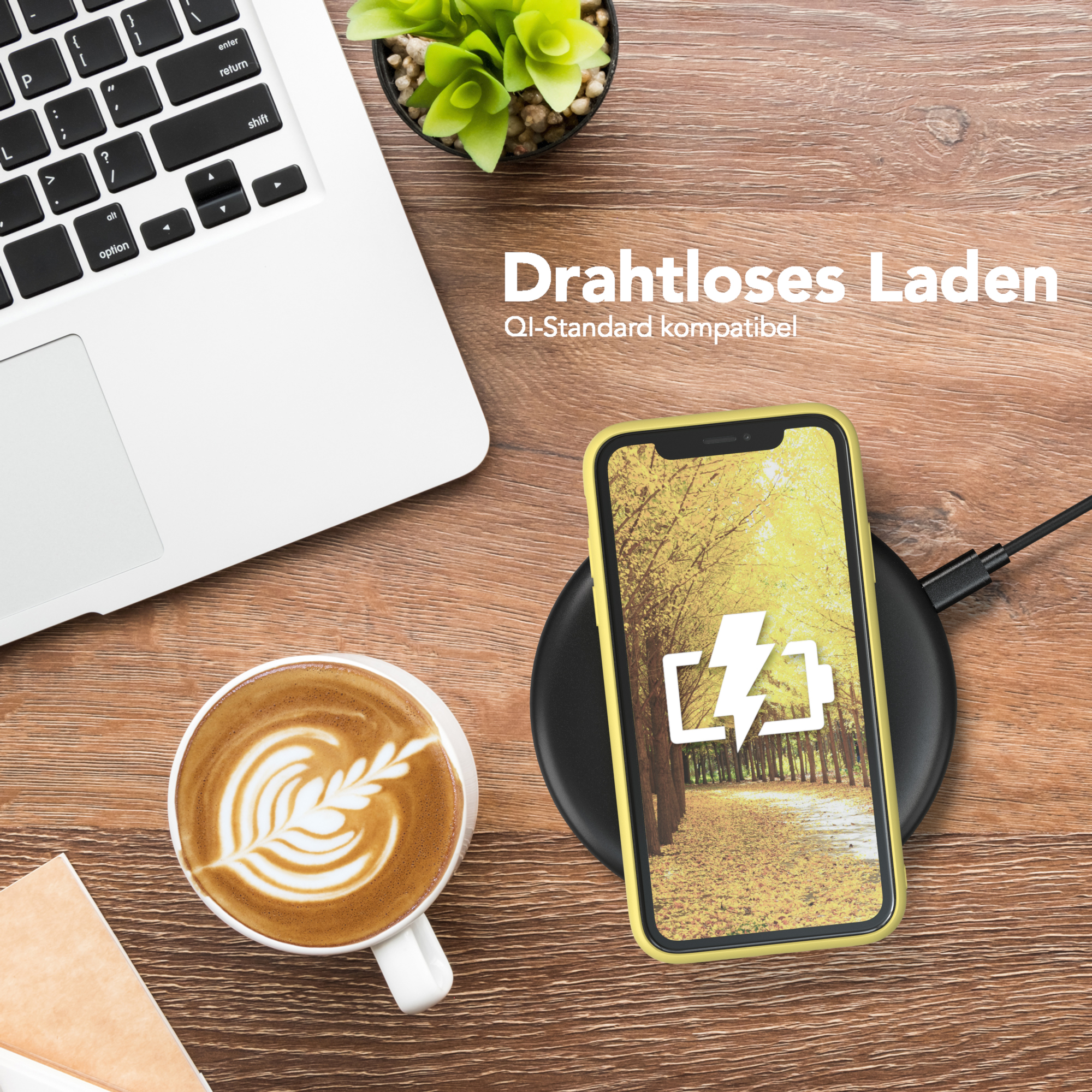 Ein Telefon, das drahtlos auf einem schwarzen Pad neben einer Tasse Kaffee geladen wird.