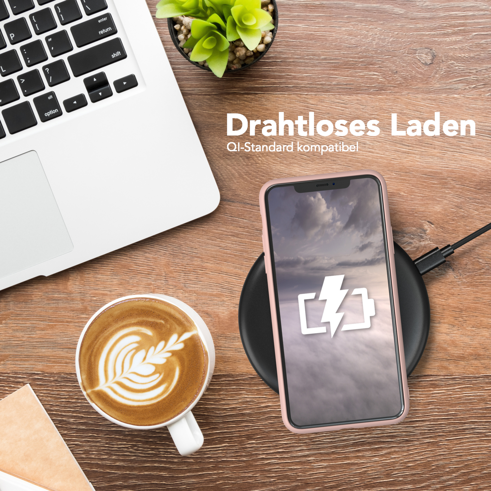 Ein Telefon wird drahtlos auf einem Holztisch aufgeladen. Eine Tasse Kaffee steht daneben. Eine grüne Pflanze steht ebenfalls auf dem Tisch.