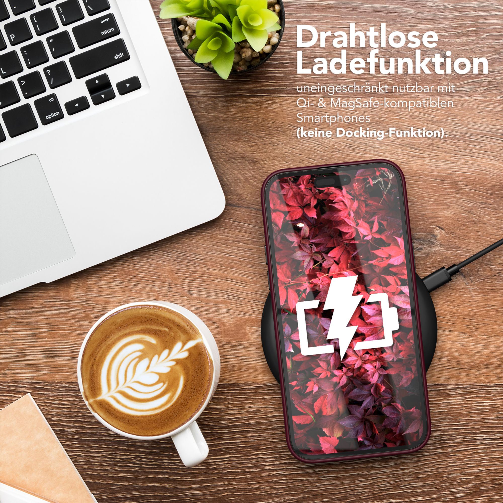 Ein Telefon auf einem kabellosen Ladegerät, eine Kaffeetasse und ein Laptop auf einem Holztisch.