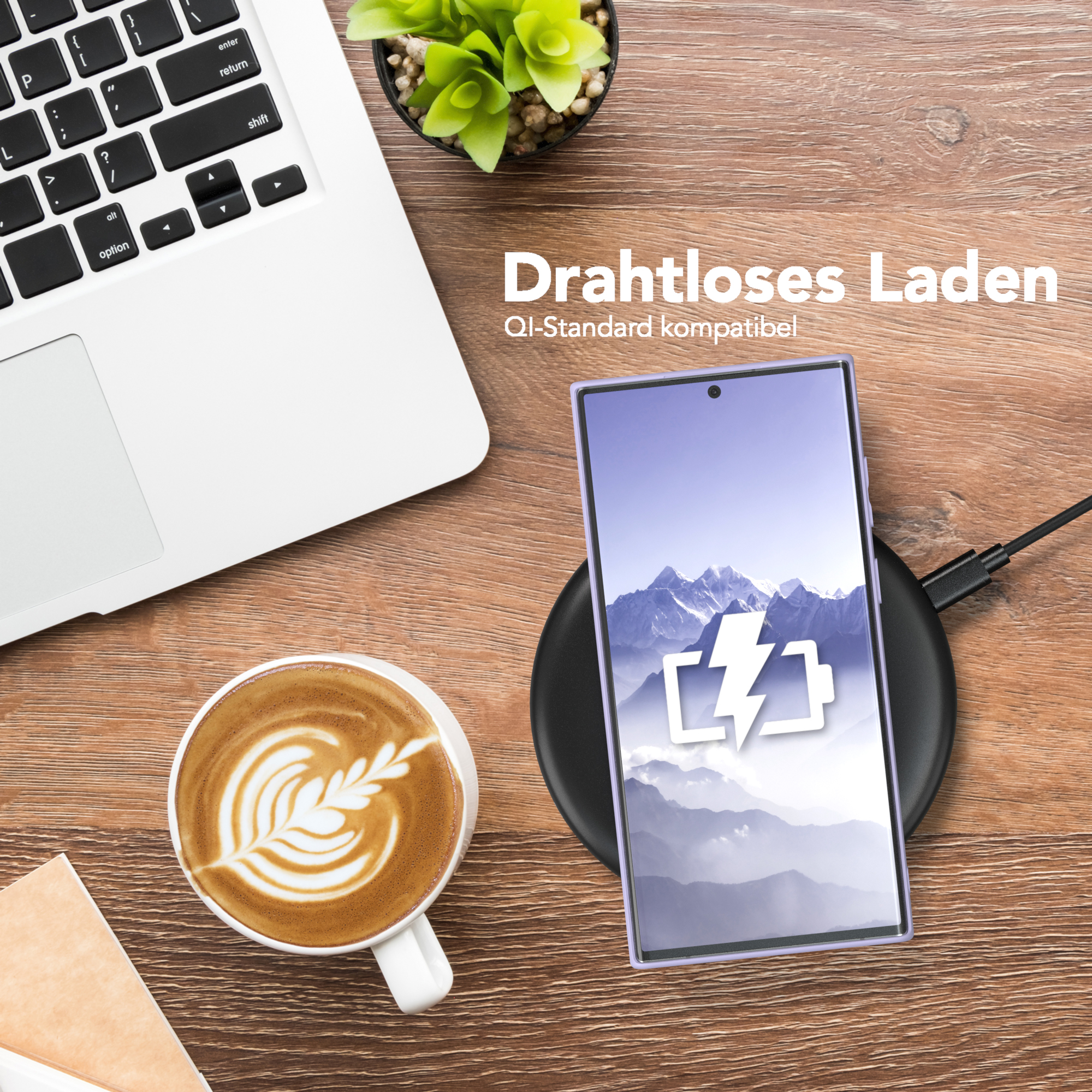 Ein Telefon auf einem kabellosen Ladegerät, neben einem Laptop und einer Kaffeetasse.