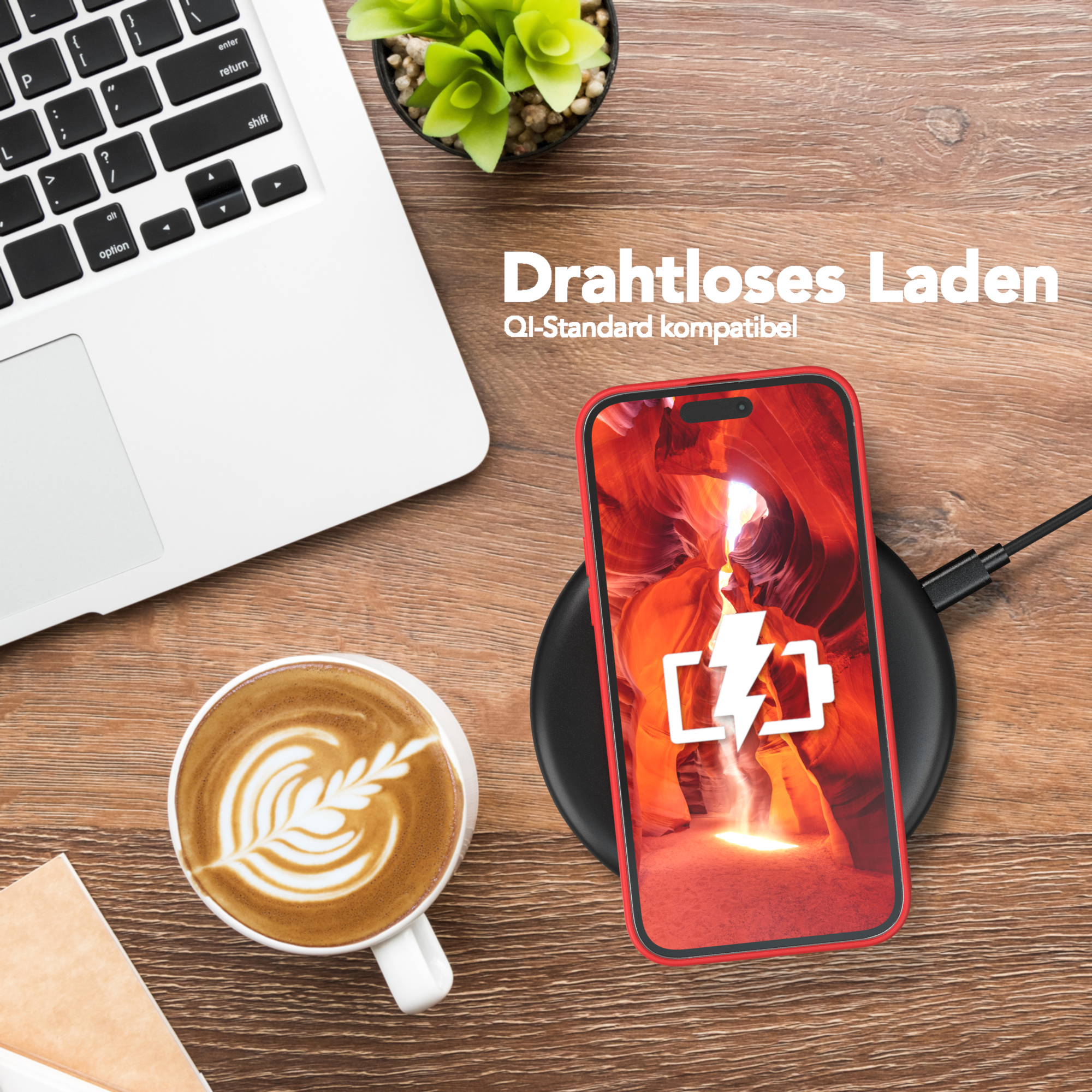 Ein Laptop, eine Kaffeetasse mit Latte Art und ein Telefon auf einem kabellosen Ladegerät. Rote Handyhülle.