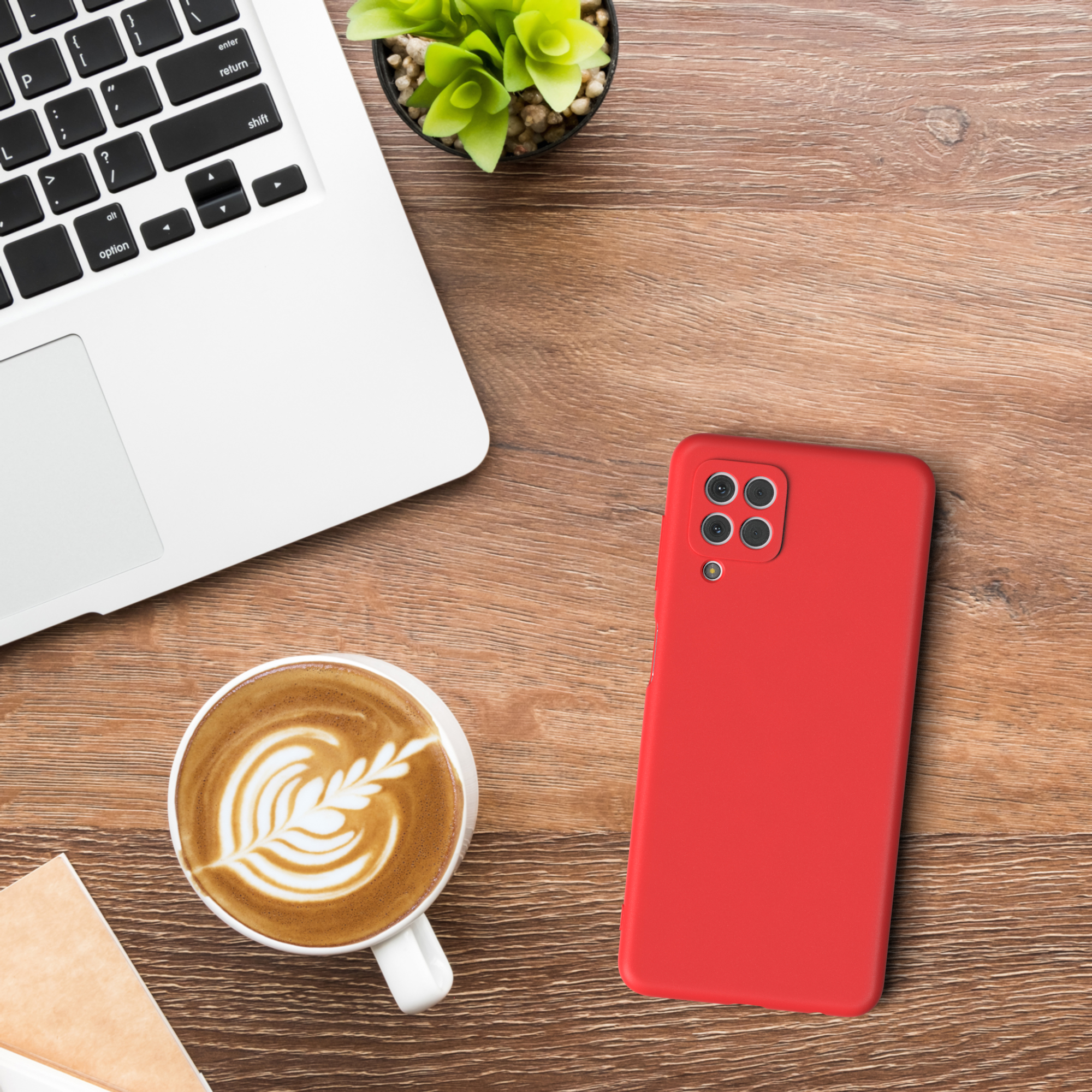 Laptop, Kaffee, Telefon und Hülle auf einem Holzschreibtisch. Die Handyhülle ist rot.