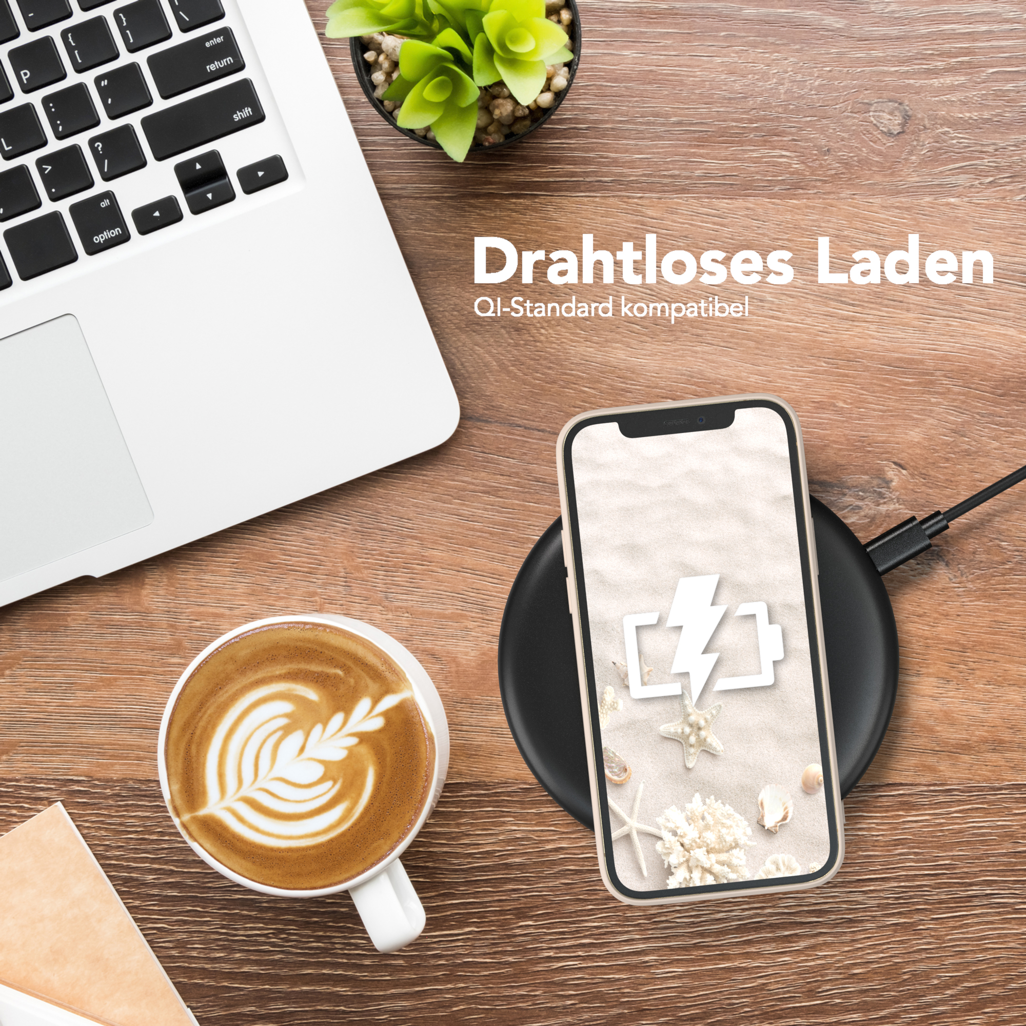 Ein Laptop, Kaffee mit Latte Art und ein Telefon auf einem kabellosen Ladegerät liegen auf einem Holzschreibtisch.