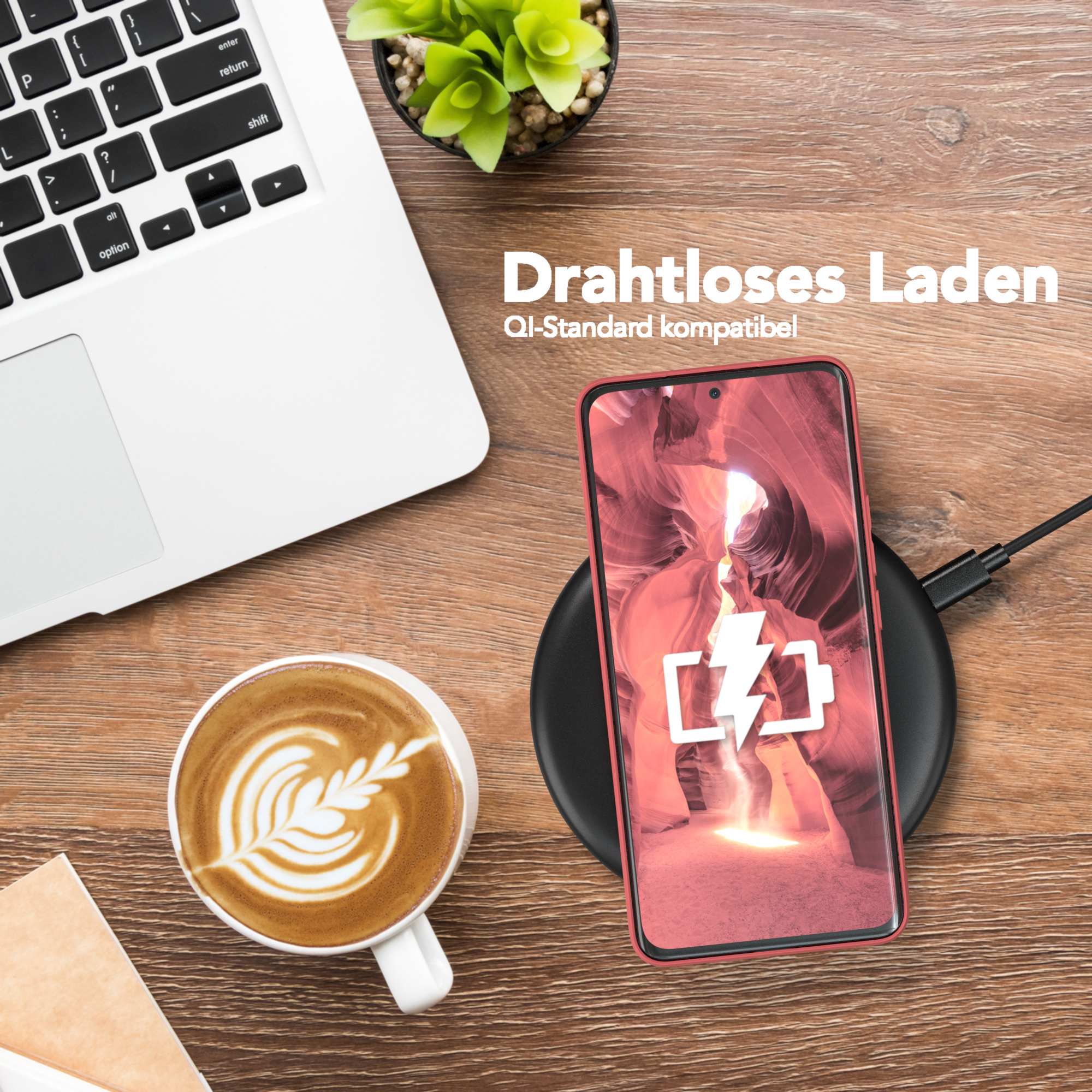 Laptop, Kaffee, Pflanze und Telefon auf Ladegerät. Telefon ist rot mit rotem Case. Holz.