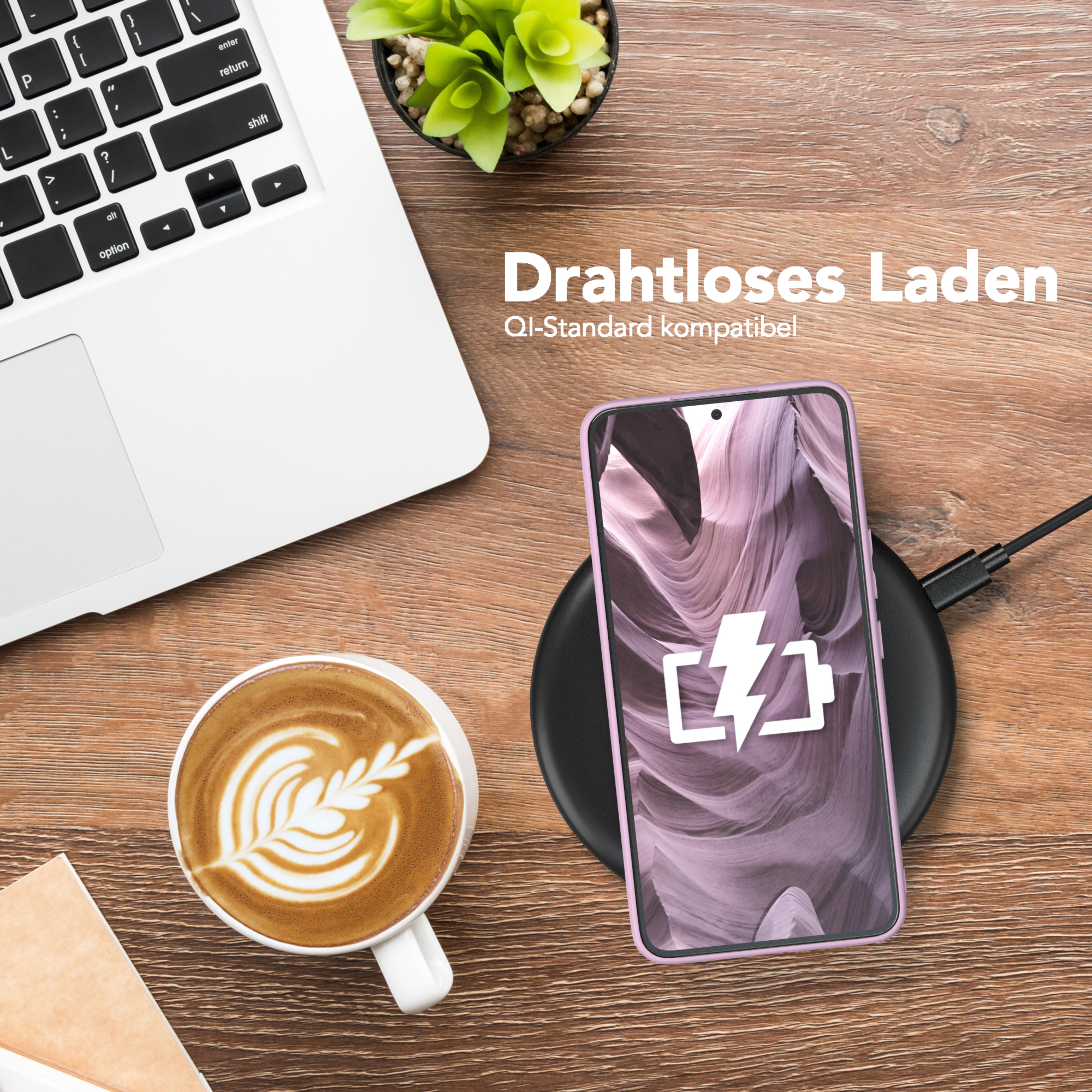 Ein Telefon auf einem kabellosen Ladegerät neben einem Laptop, einer Kaffeetasse und einer Pflanze.