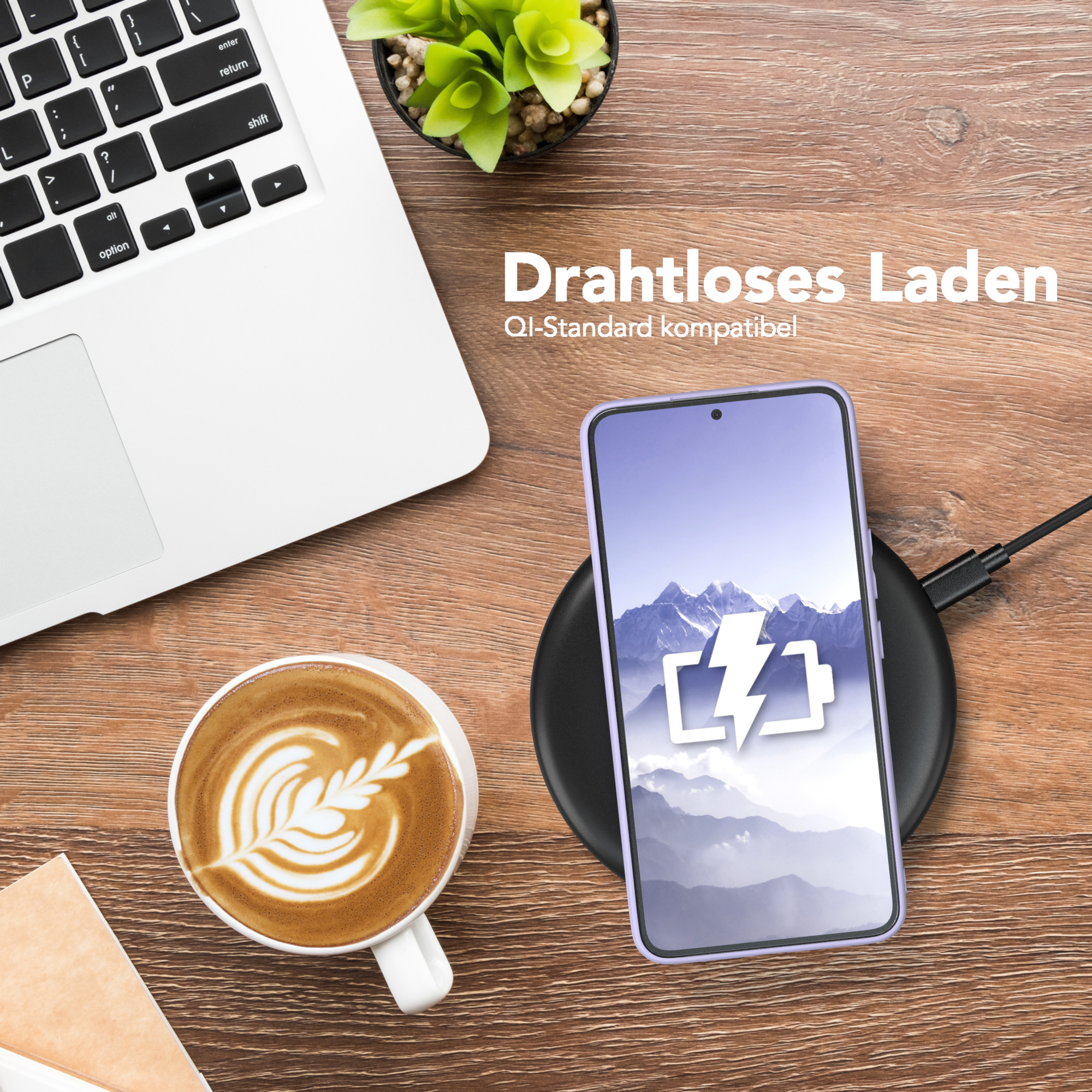 Ein Telefon auf einem kabellosen Ladegerät neben einem Laptop, einer Kaffeetasse und einer Pflanze.