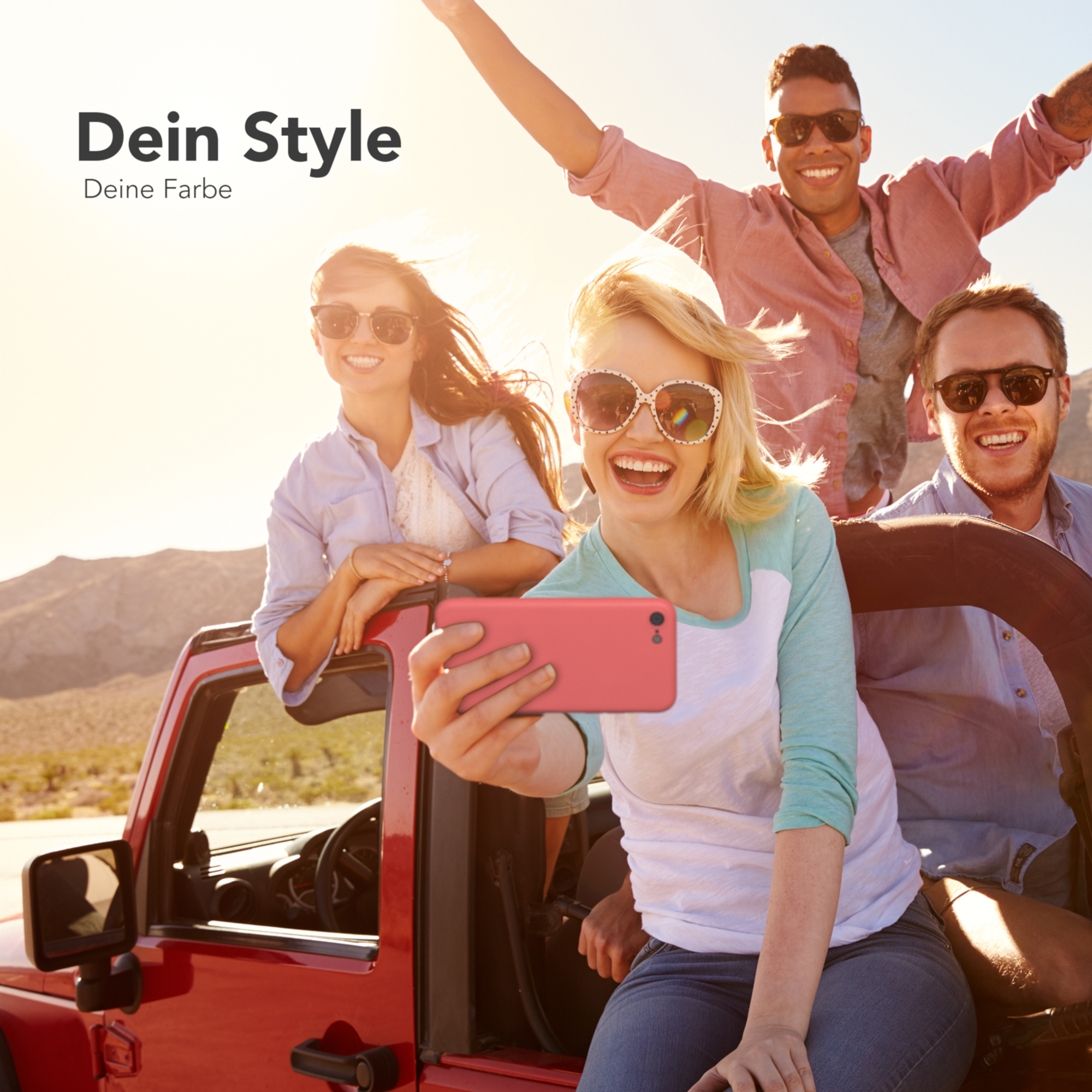Vierköpfige Gruppe in einem roten Jeep, die bei sonnigem Wetter ein Selfie mit einer pinkfarbenen Handyhülle macht.
