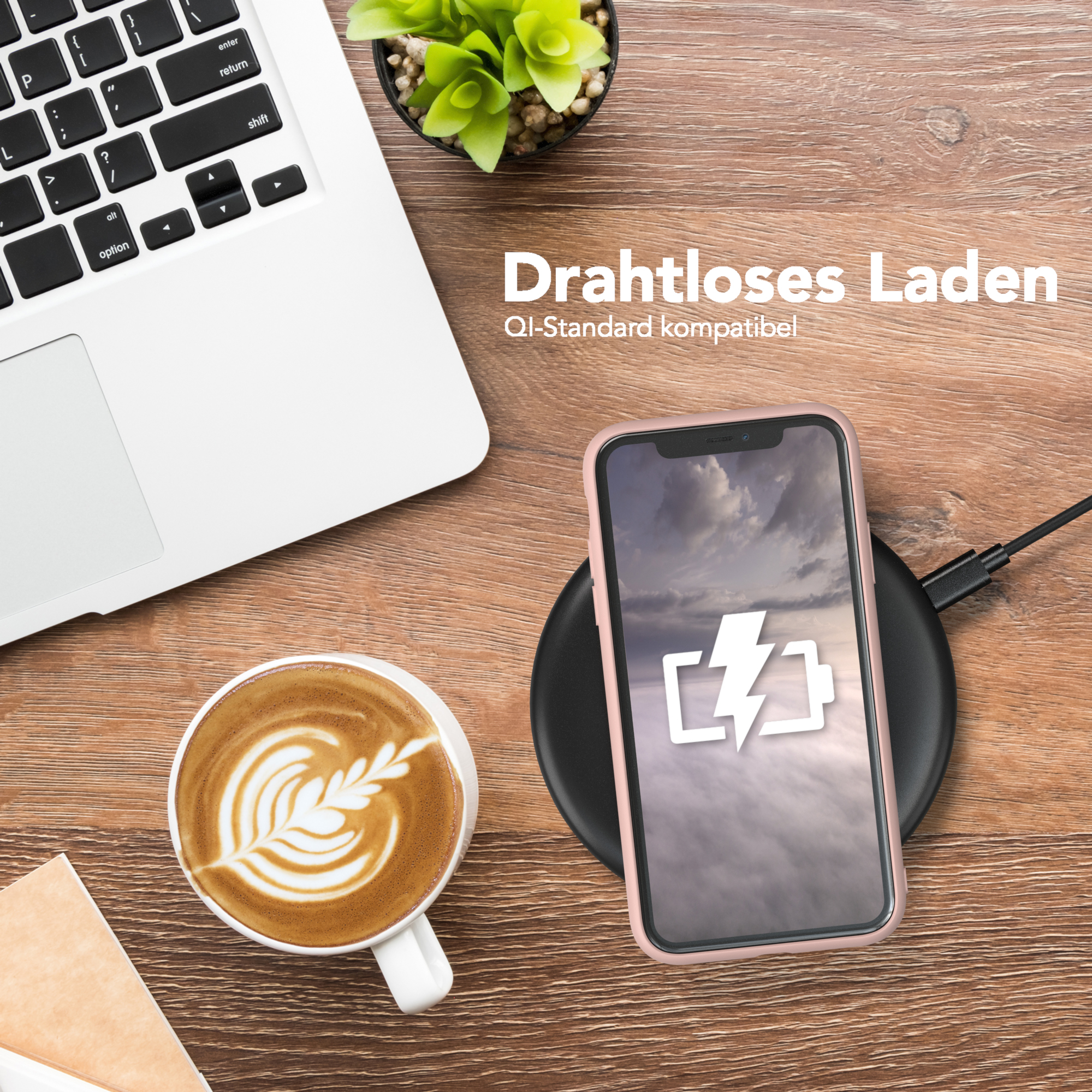 Ein Telefon auf einem kabellosen Ladegerät neben einer Tasse Kaffee und einem Laptop.