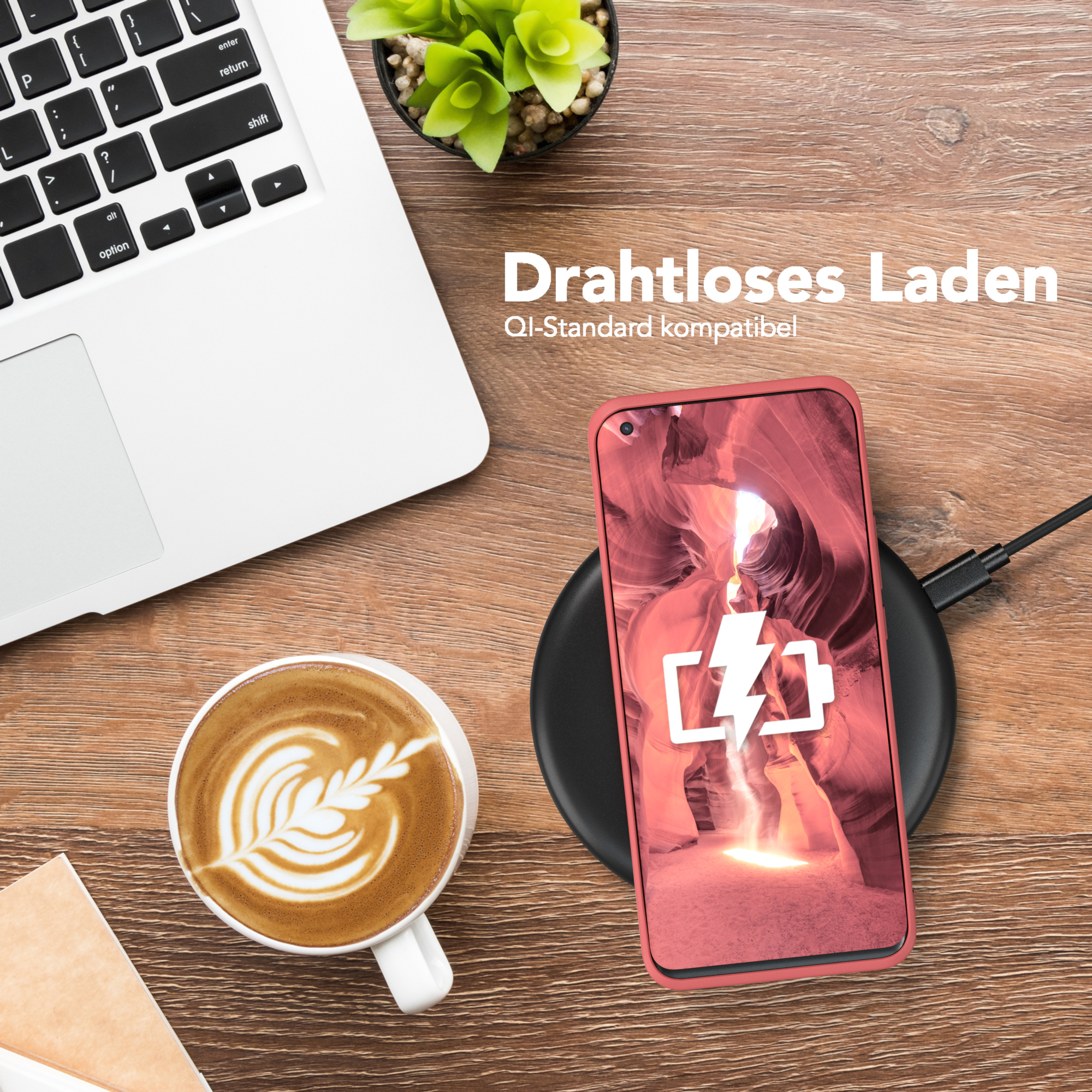 Ein Handy auf einer kabellosen Ladestation, neben einem Laptop, Kaffee und einer Pflanze. Das Handy zeigt einen Blitz.