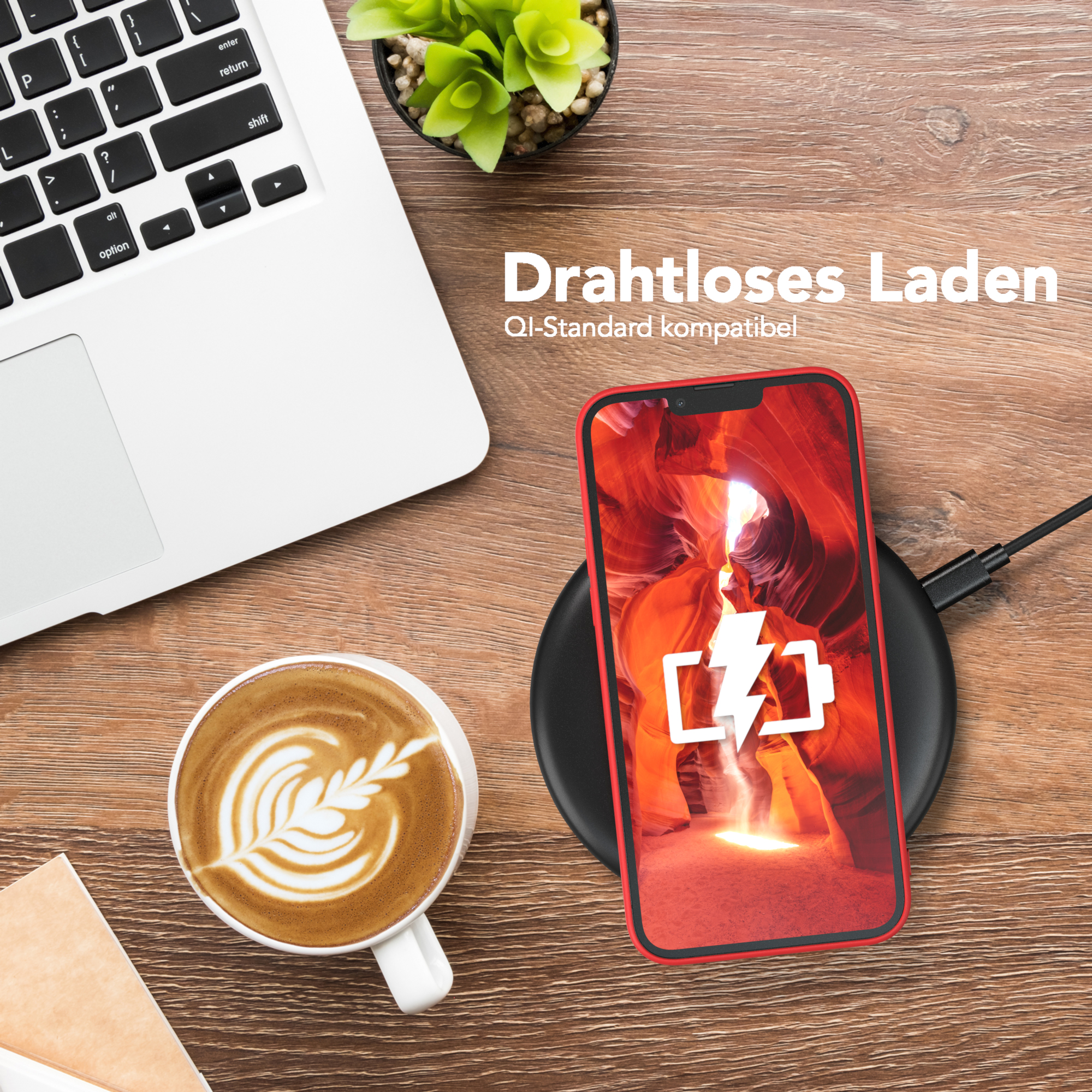 Telefon wird drahtlos auf einem schwarzen Pad geladen. Laptop und Kaffeetasse stehen in der Nähe.