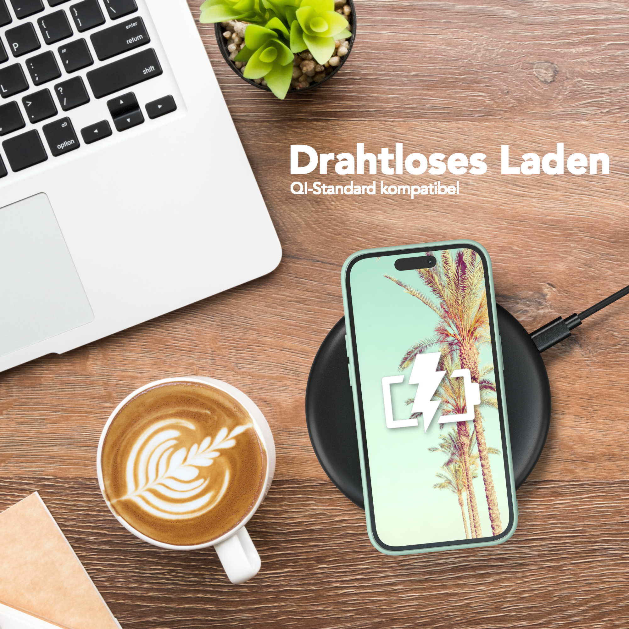 Telefon kabellos laden. Ein Telefon mit hellgrüner Hülle liegt auf einem schwarzen Ladepad. Laptop, Kaffee und Pflanze in der Nähe.