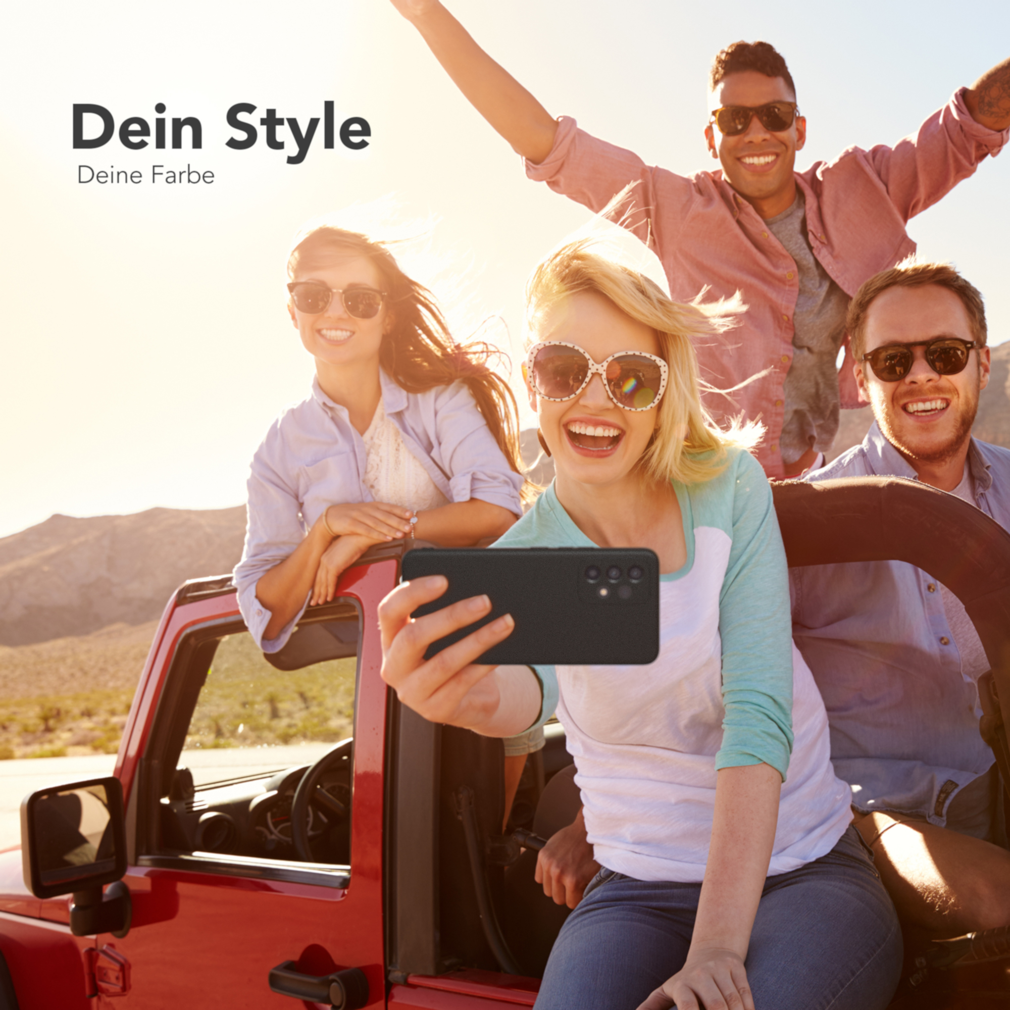 Vier Personen mit Sonnenbrille posieren in einem roten Jeep, einer macht ein Selfie.