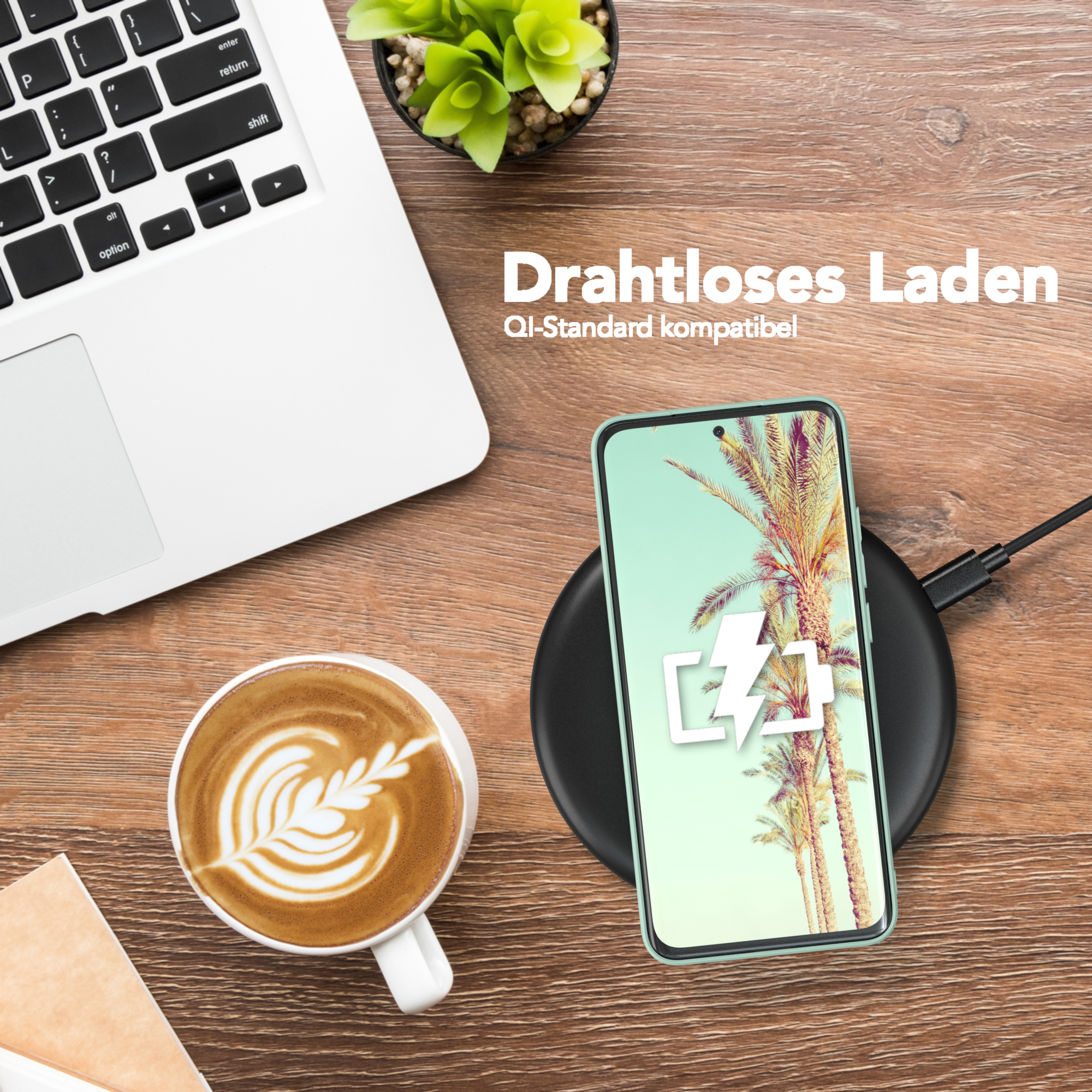 Ein Telefon, das drahtlos geladen wird, mit einem geöffneten Laptop und einer Tasse Kaffee auf einem Holztisch.