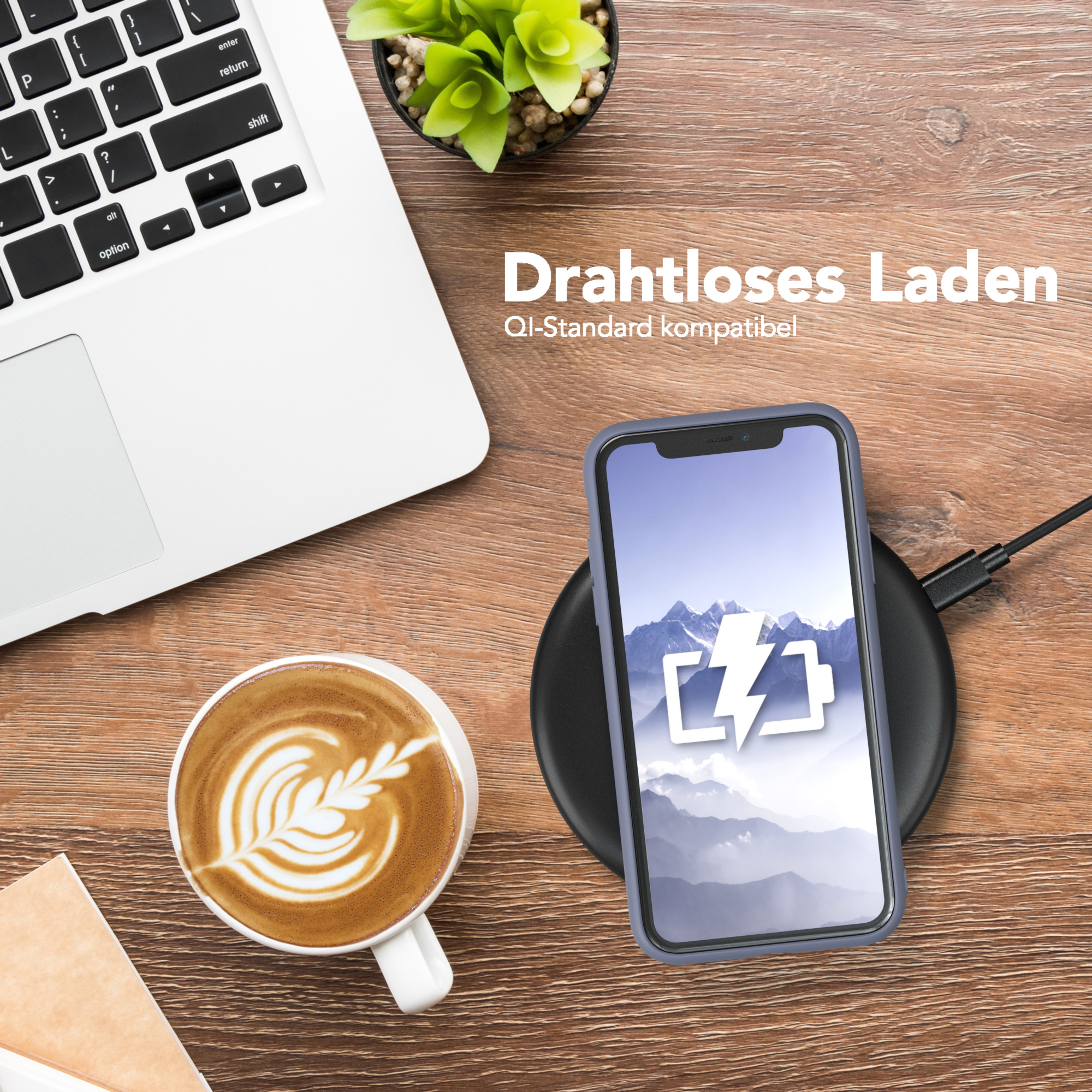 Telefon auf kabellosem Ladegerät neben Laptop und Kaffee.