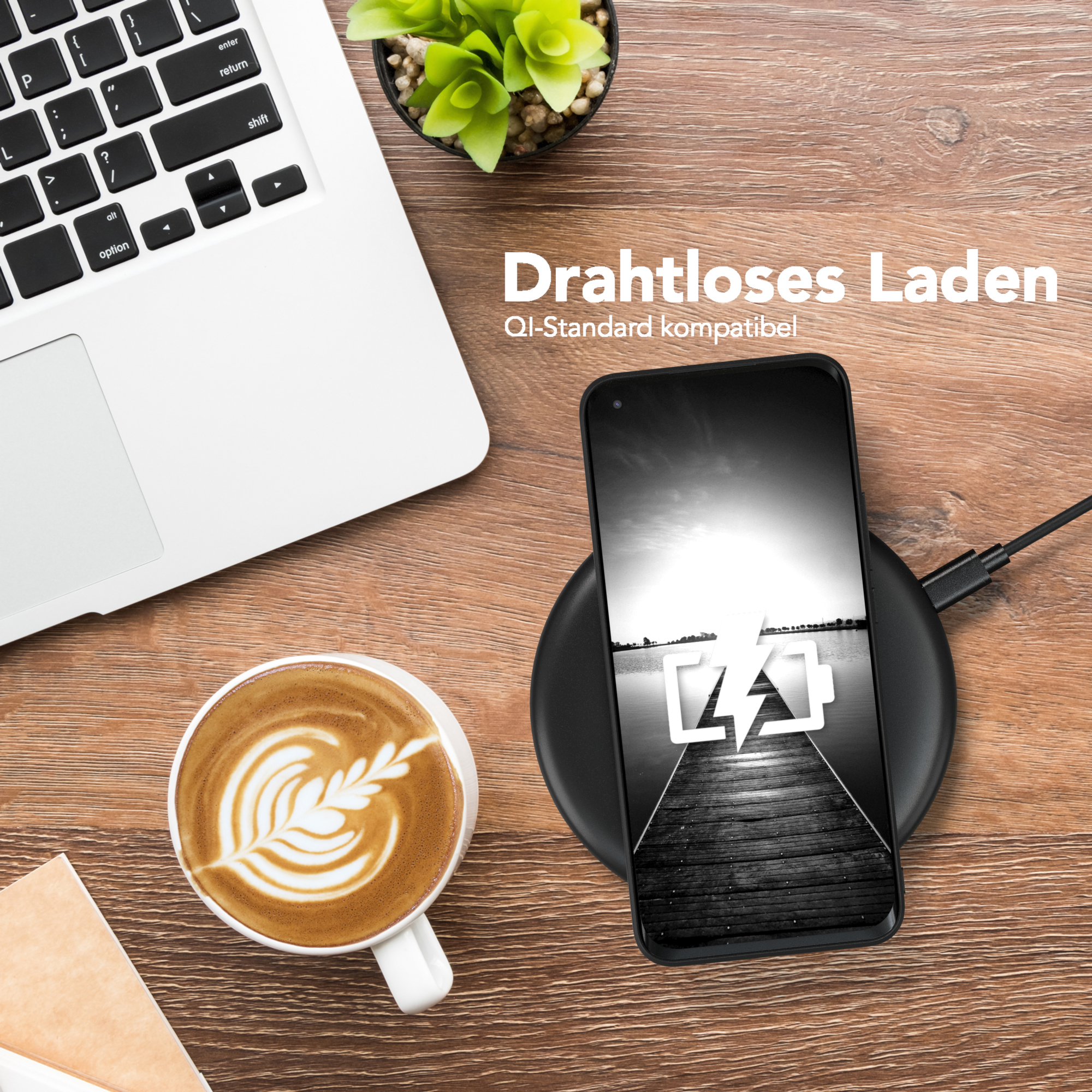 Telefon wird auf einem kabellosen Ladegerät geladen, mit Kaffee und einem Laptop, auf einem Holztisch.