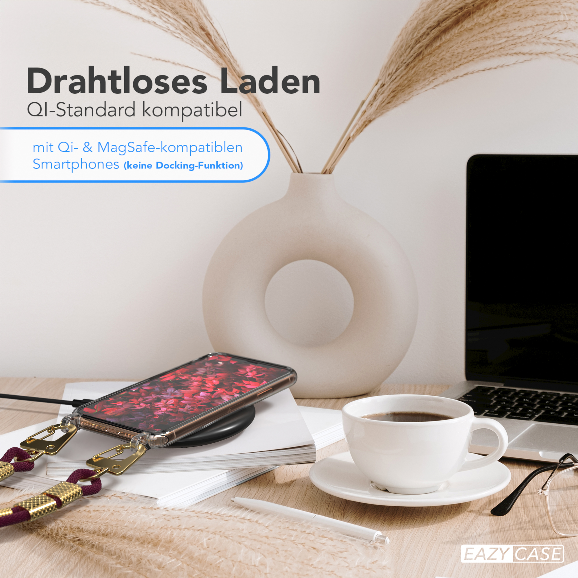 Telefon mit Lanyard auf einem kabellosen Ladegerät, mit einer Tasse Kaffee und einem Laptop.