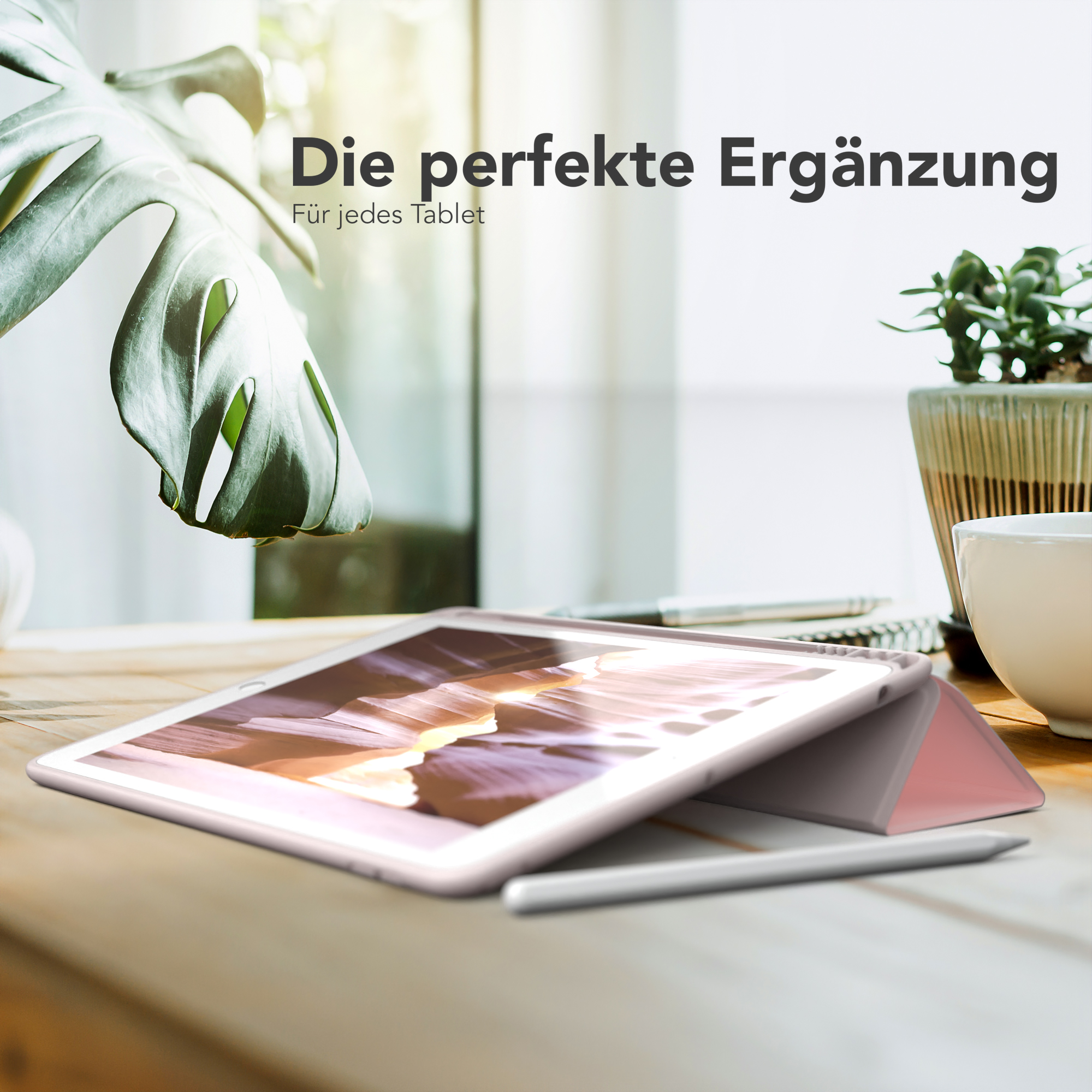 Tablet mit pinkfarbener Hülle, Holztisch, Pflanze, Stift und Text: Die perfekte Ergänzung.