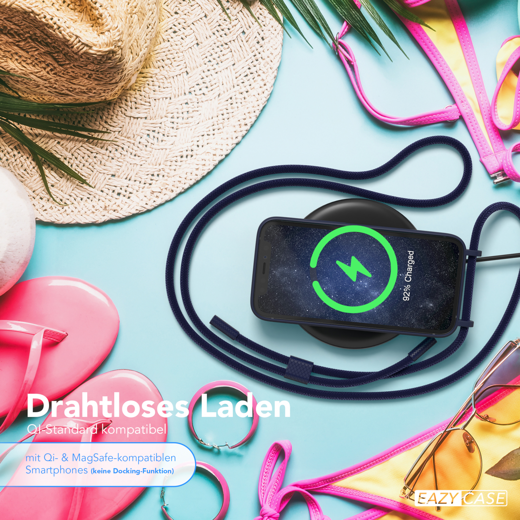Telefon wird drahtlos auf einem Pad aufgeladen. Umgeben von Strandutensilien wie Hut und Sonnenbrille.