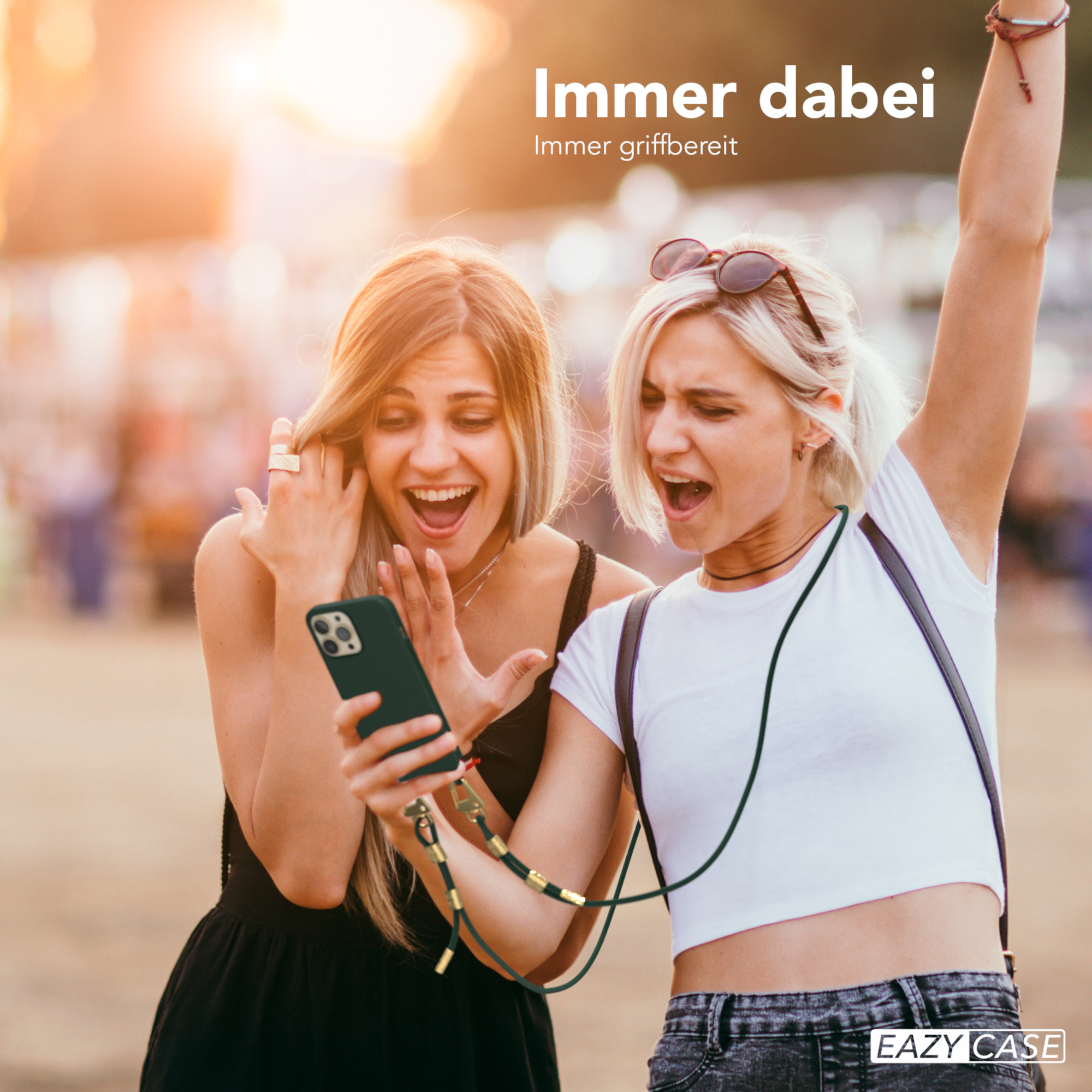 Zwei Frauen betrachten ein Telefon mit Lanyard in sonniger Umgebung im Freien.