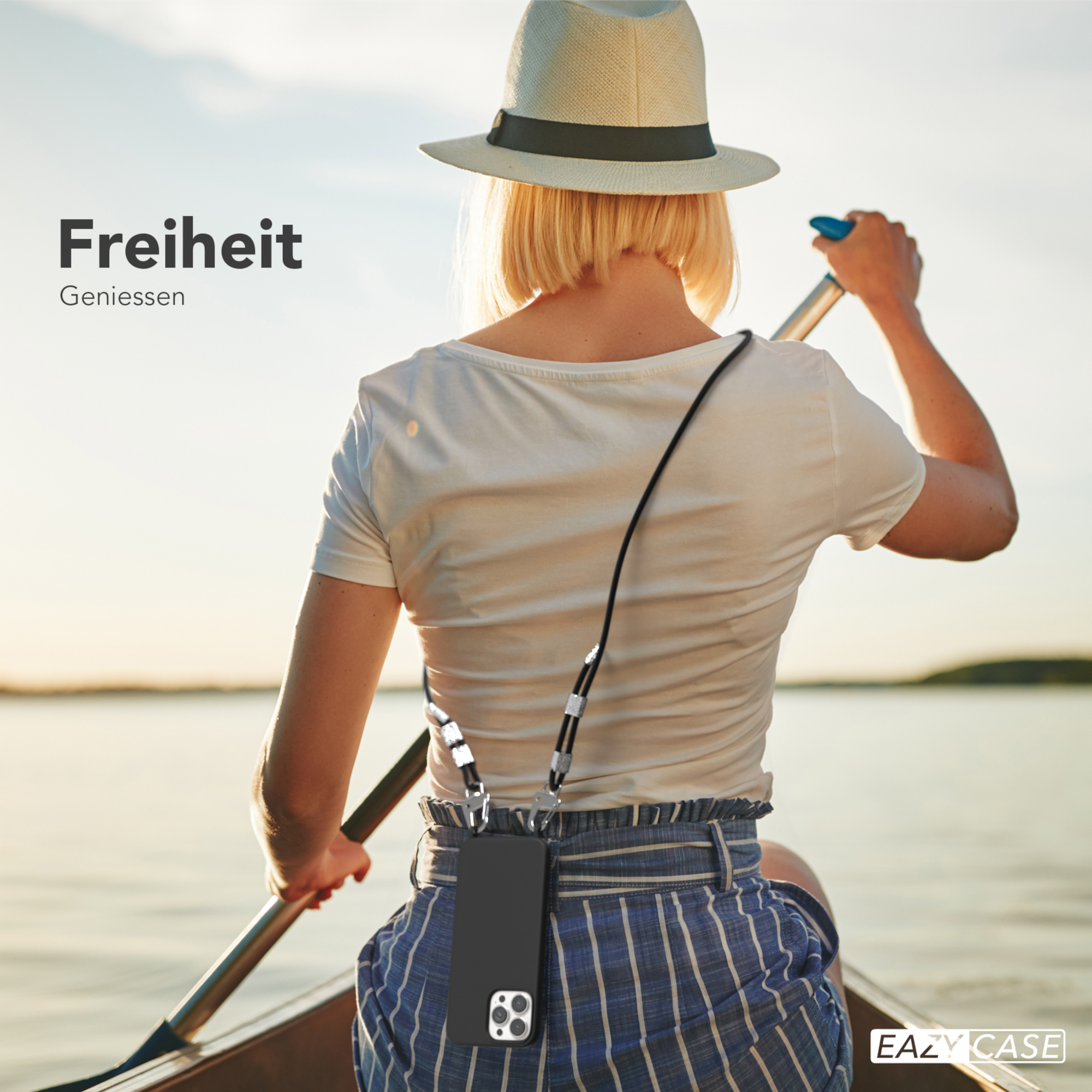 Frau rudert auf einem See mit Handyhülle um den Hals.