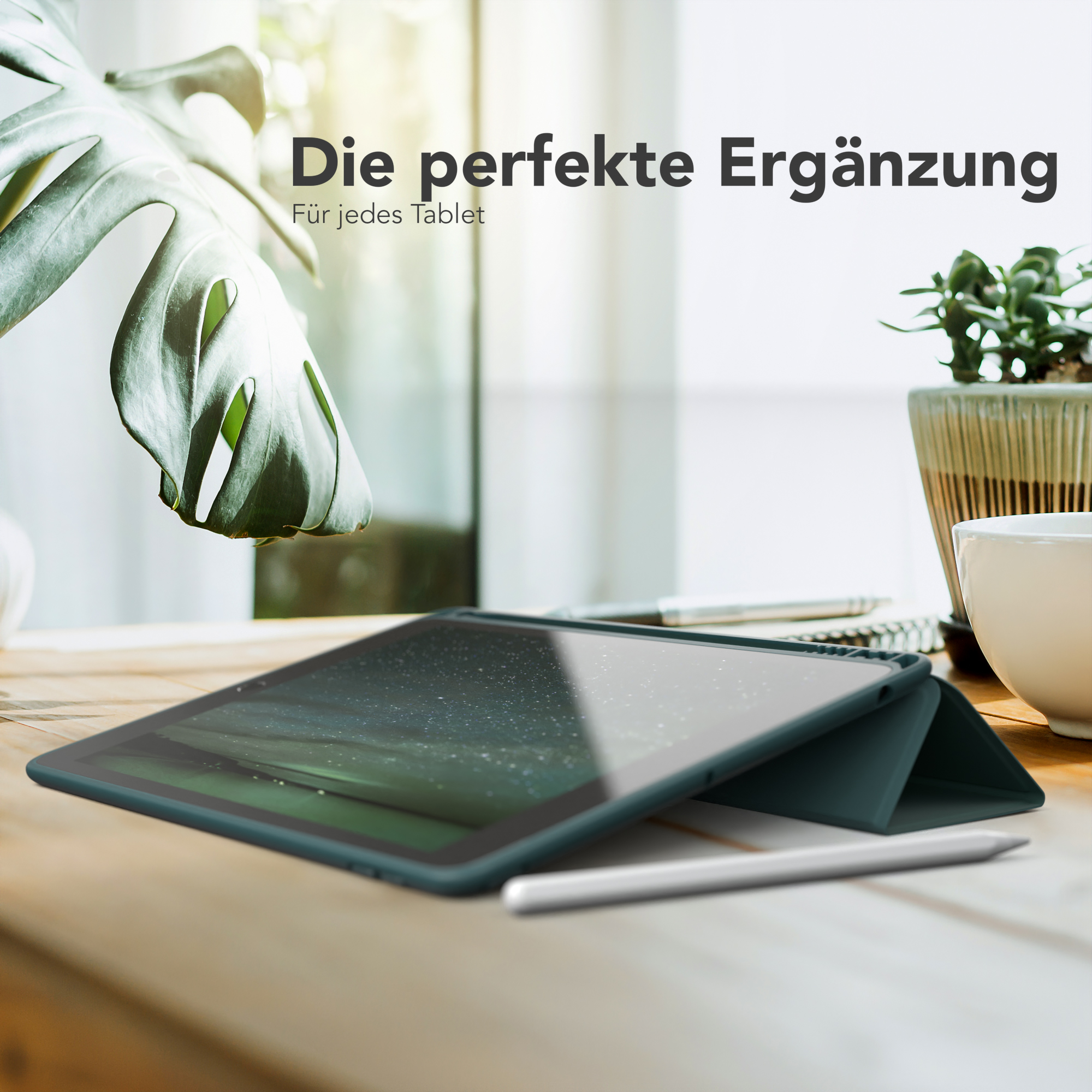 Ein Tablet in einer Hülle auf einem Holztisch mit einem Stift und einer Pflanze.