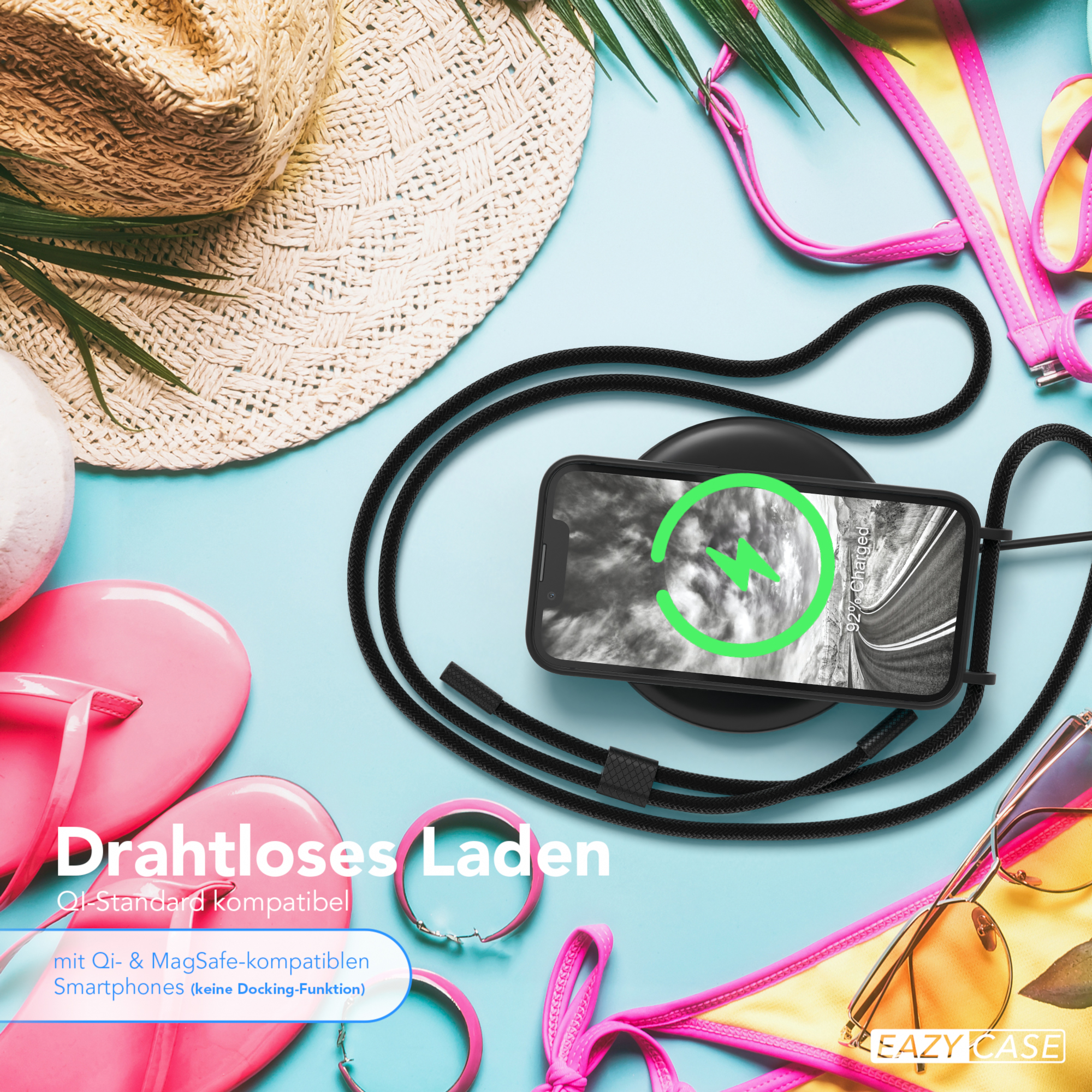 Ein Telefon, das auf einem schwarzen, kabellosen Ladegerät geladen wird, mit Strandaccessoires im Hintergrund.