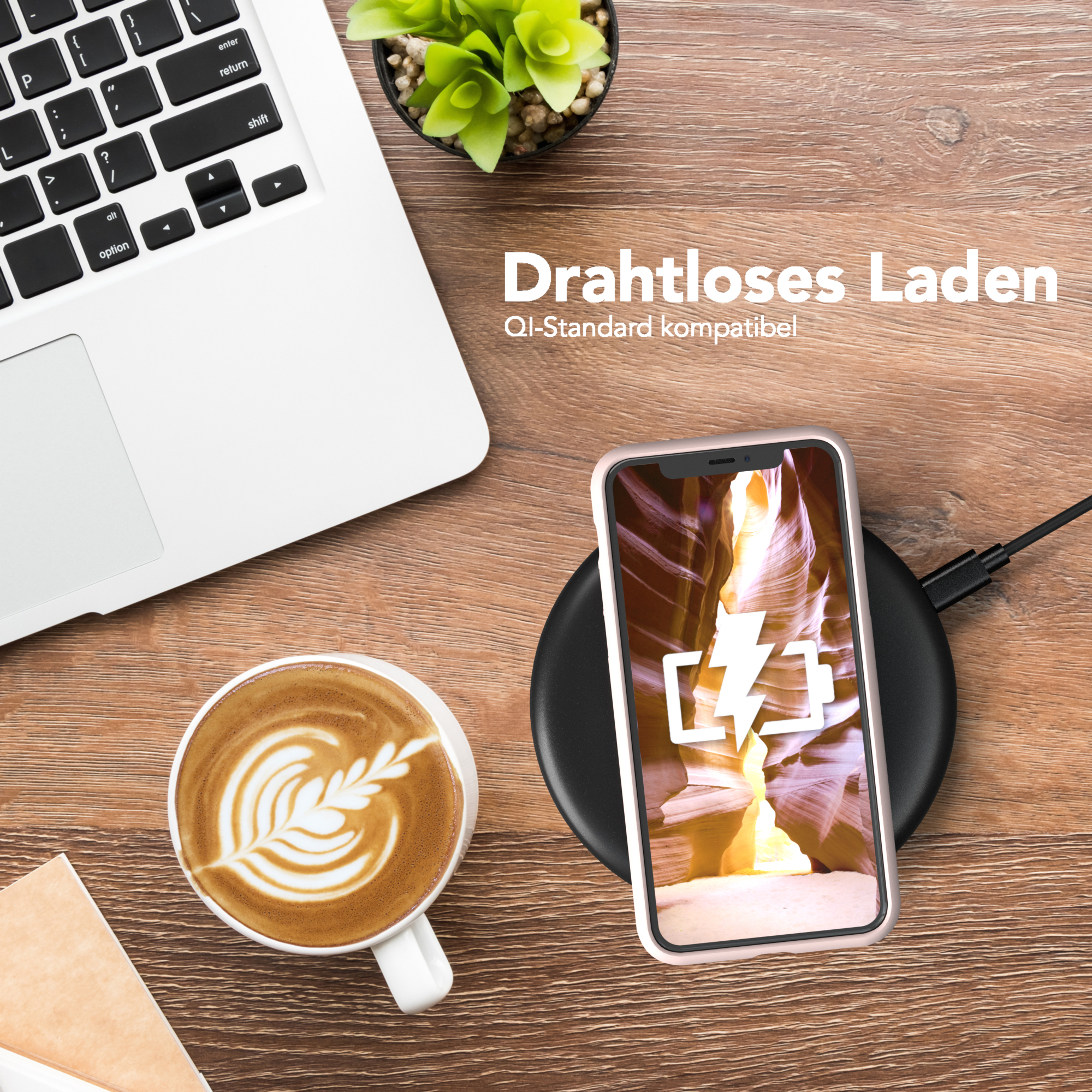 Telefon lädt kabellos auf einem Pad neben Kaffee und Laptop, auf einem Holzschreibtisch.