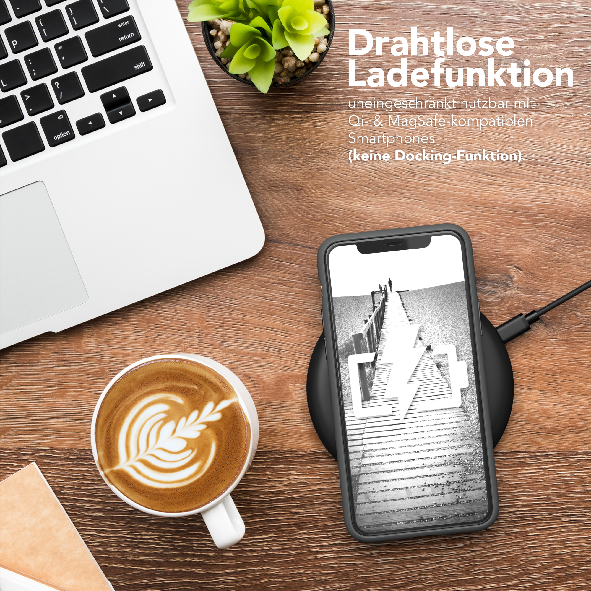 Laptop, Kaffee mit Latte Art, Telefon lädt auf Pad auf Holzschreibtisch.