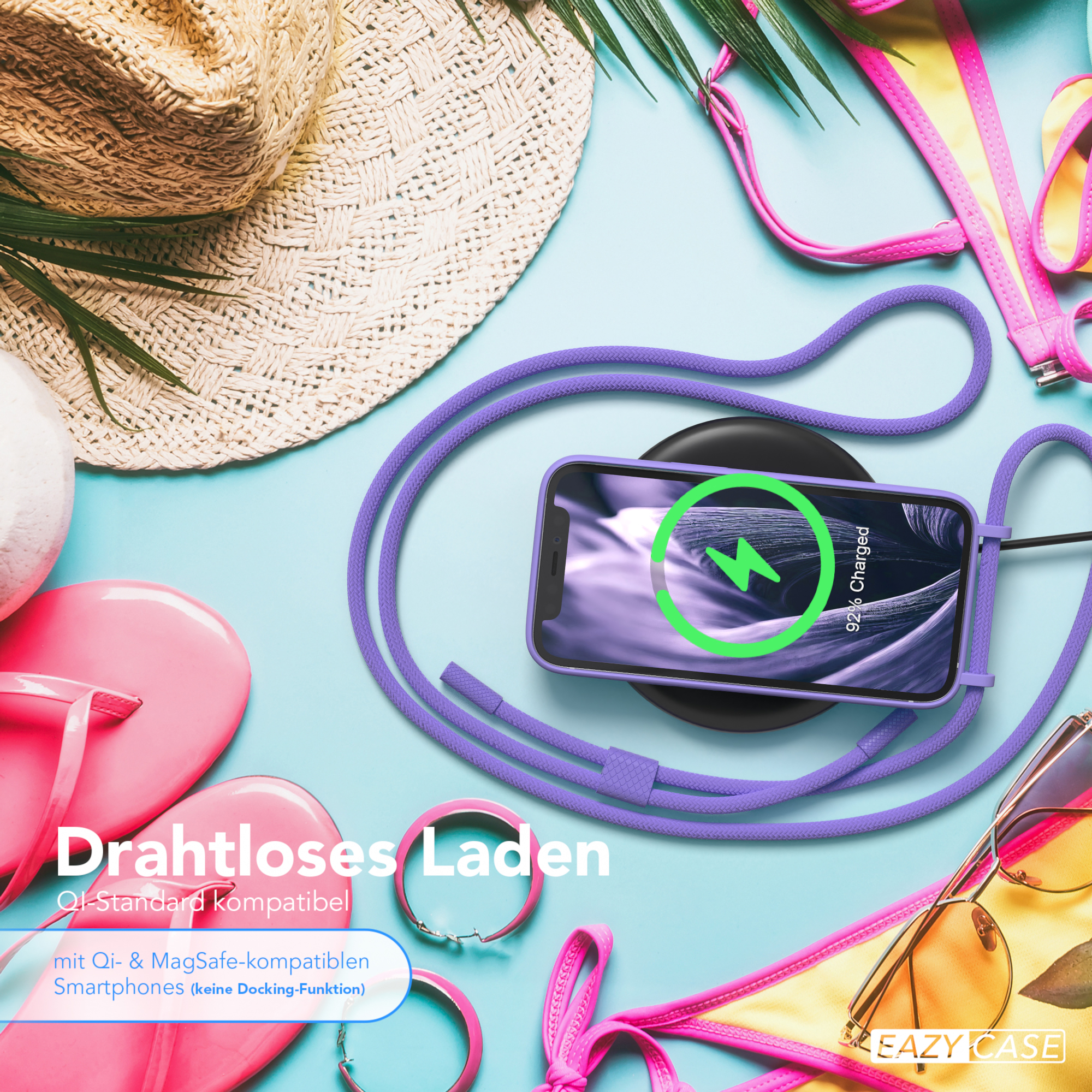 Telefon lädt an lila Kabel, umgeben von Strandutensilien: Hut, Flip-Flops und Bikini.