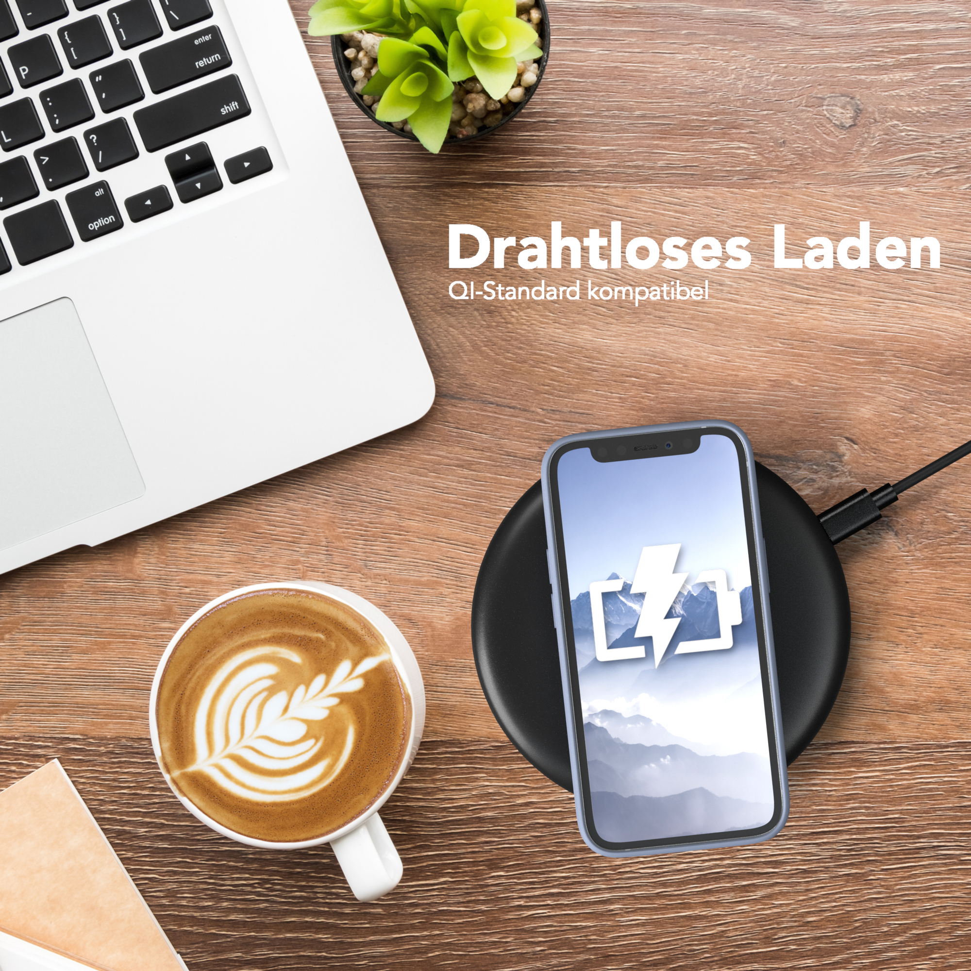 Telefon auf kabellosem Ladegerät. Kaffeetasse und Laptop auf dem Tisch.