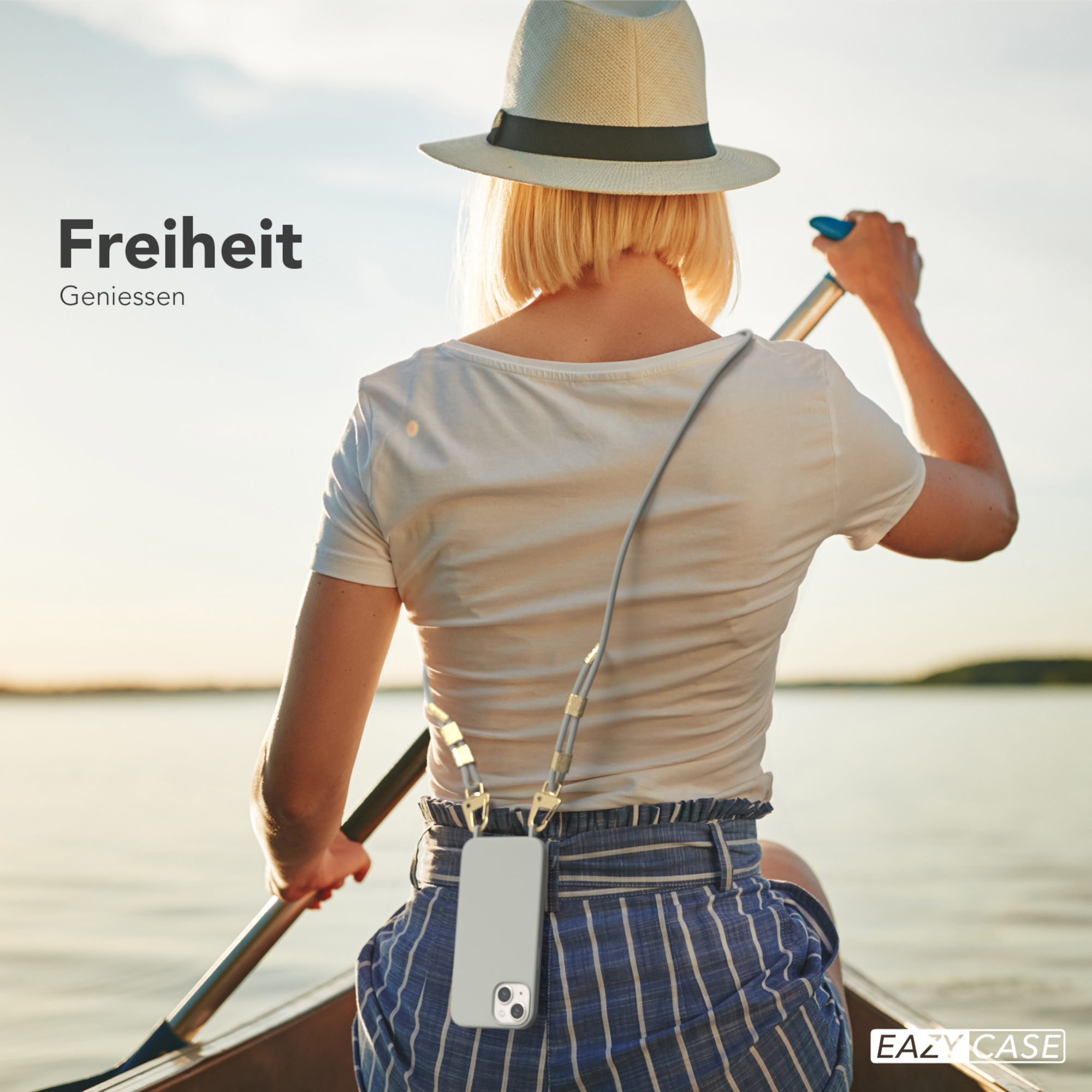 Eine Frau rudert in einem Boot. Eine Handyhülle mit Lanyard hängt um ihren Hals.