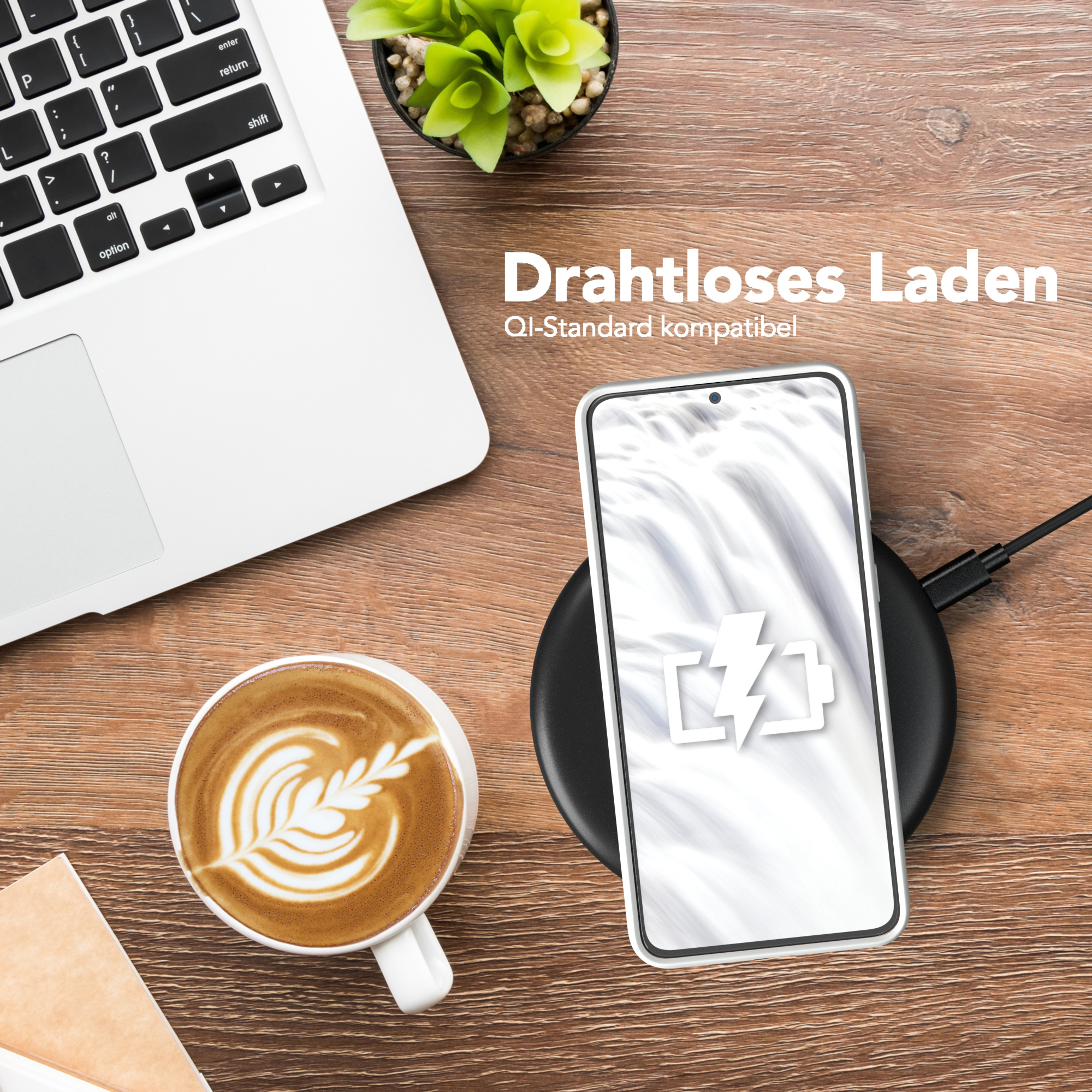 Laptop, Kaffee und Telefon auf einem kabellosen Ladegerät. Das Telefon zeigt ein Ladesymbol.