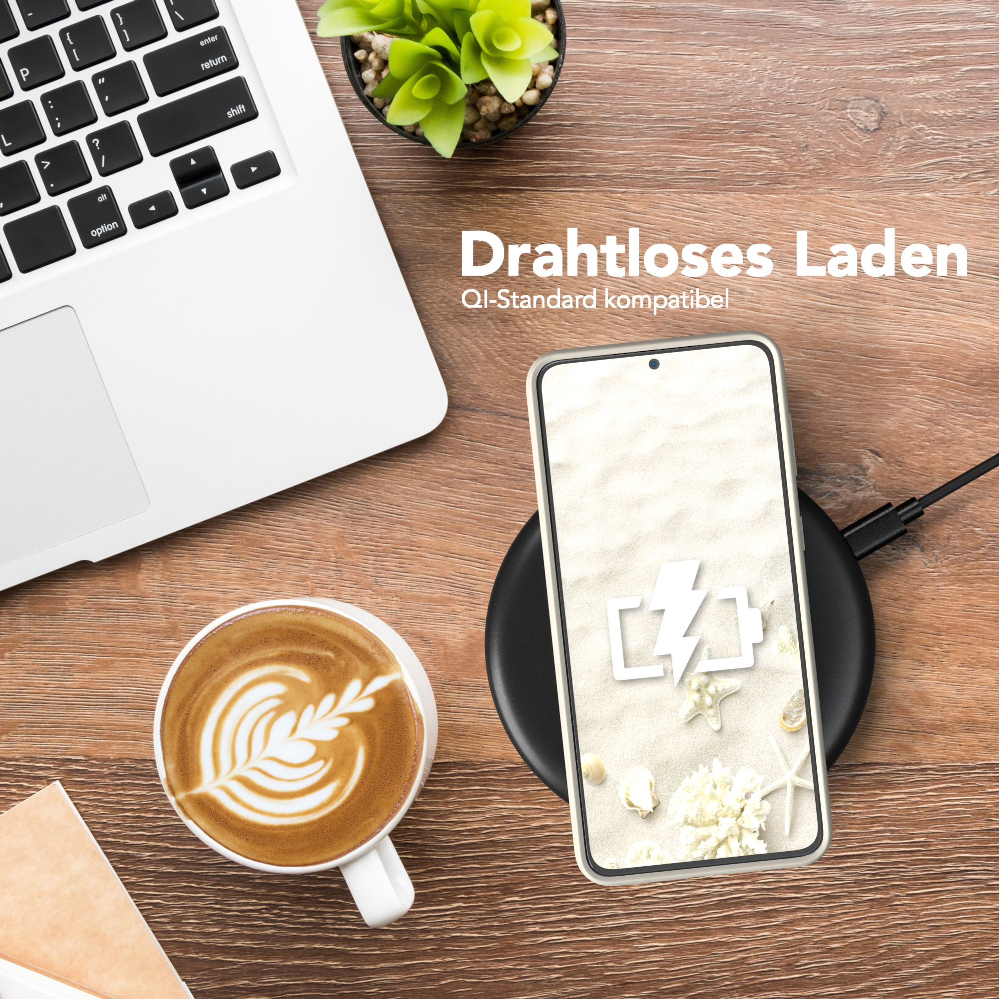 Ein Telefon, das auf einem kabellosen Ladegerät geladen wird, ein Laptop, eine Tasse Kaffee und eine Pflanze auf einem Holztisch.