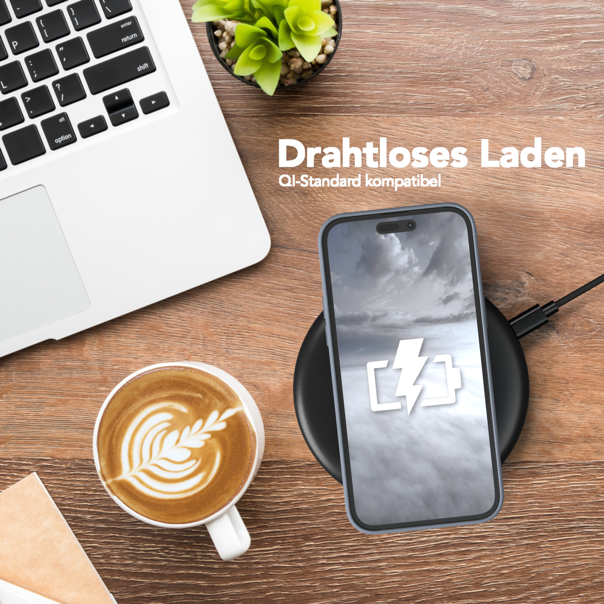 Telefon wird drahtlos auf einem schwarzen Pad geladen. Kaffee, Laptop und Pflanze im Hintergrund auf Holz.