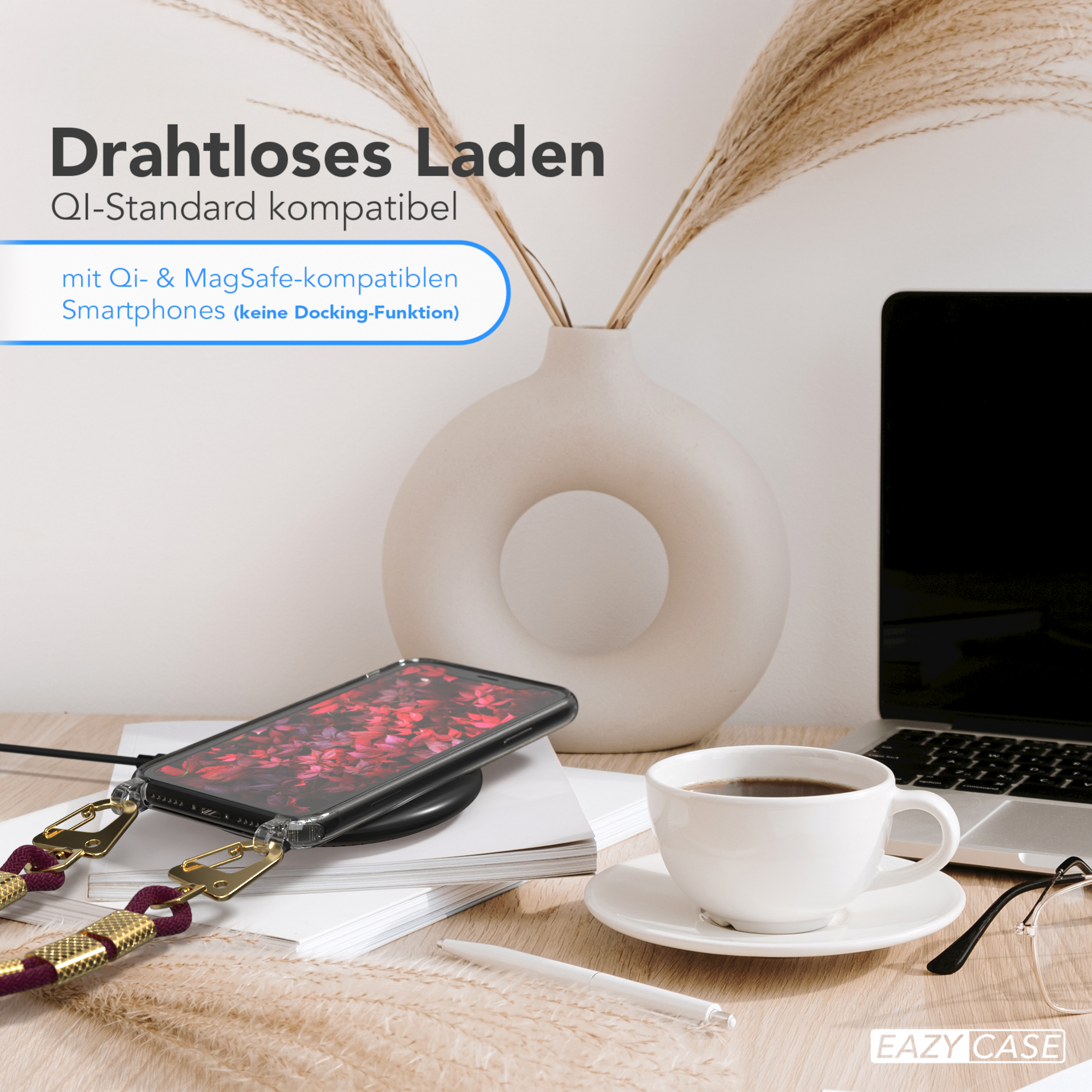 Ein Telefon auf einem kabellosen Ladegerät. Ein Laptop, Kaffee und Blumen befinden sich in der Nähe auf einer Holzoberfläche. Eine Person ist sichtbar.